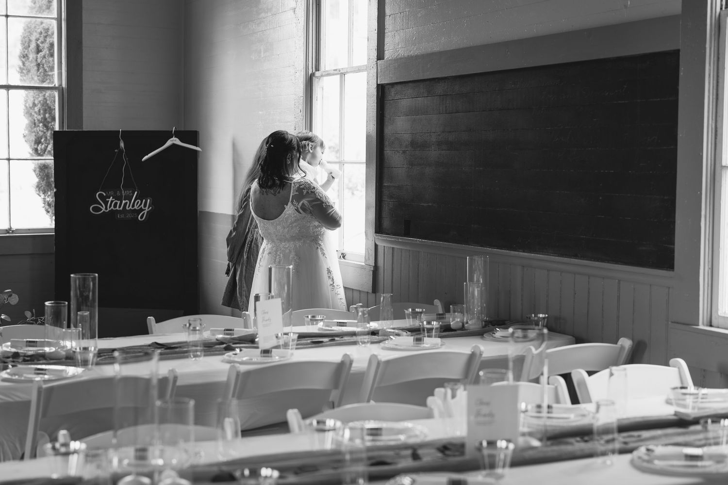 Wedding preparation scene in a vintage schoolhouse with tables and chairs.