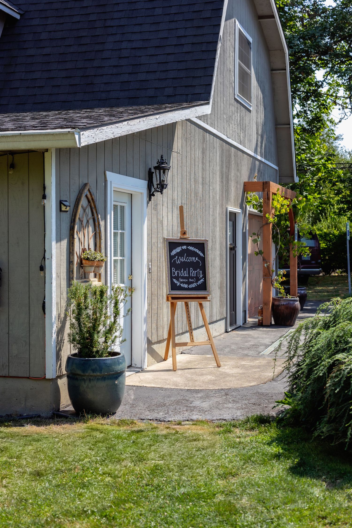 Rustic barn-style wedding venue exterior with chalkboard signs and natural landscaping.