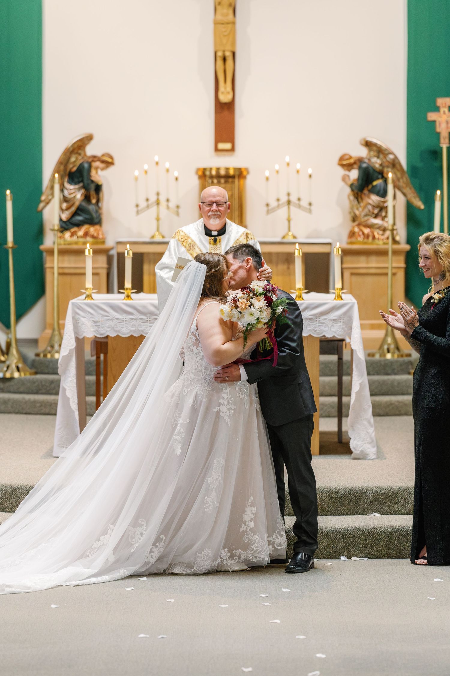 Wedding ceremony at church altar with white and gold decor elements.