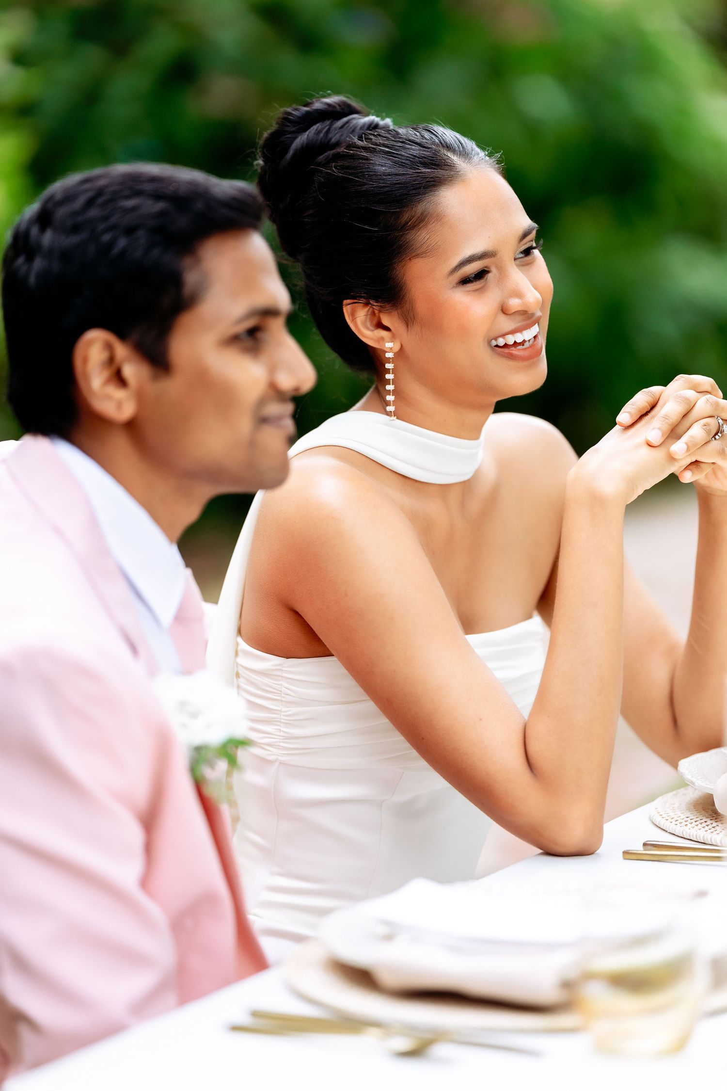 People seated at an outdoor dining table sharing laughter and conversation.