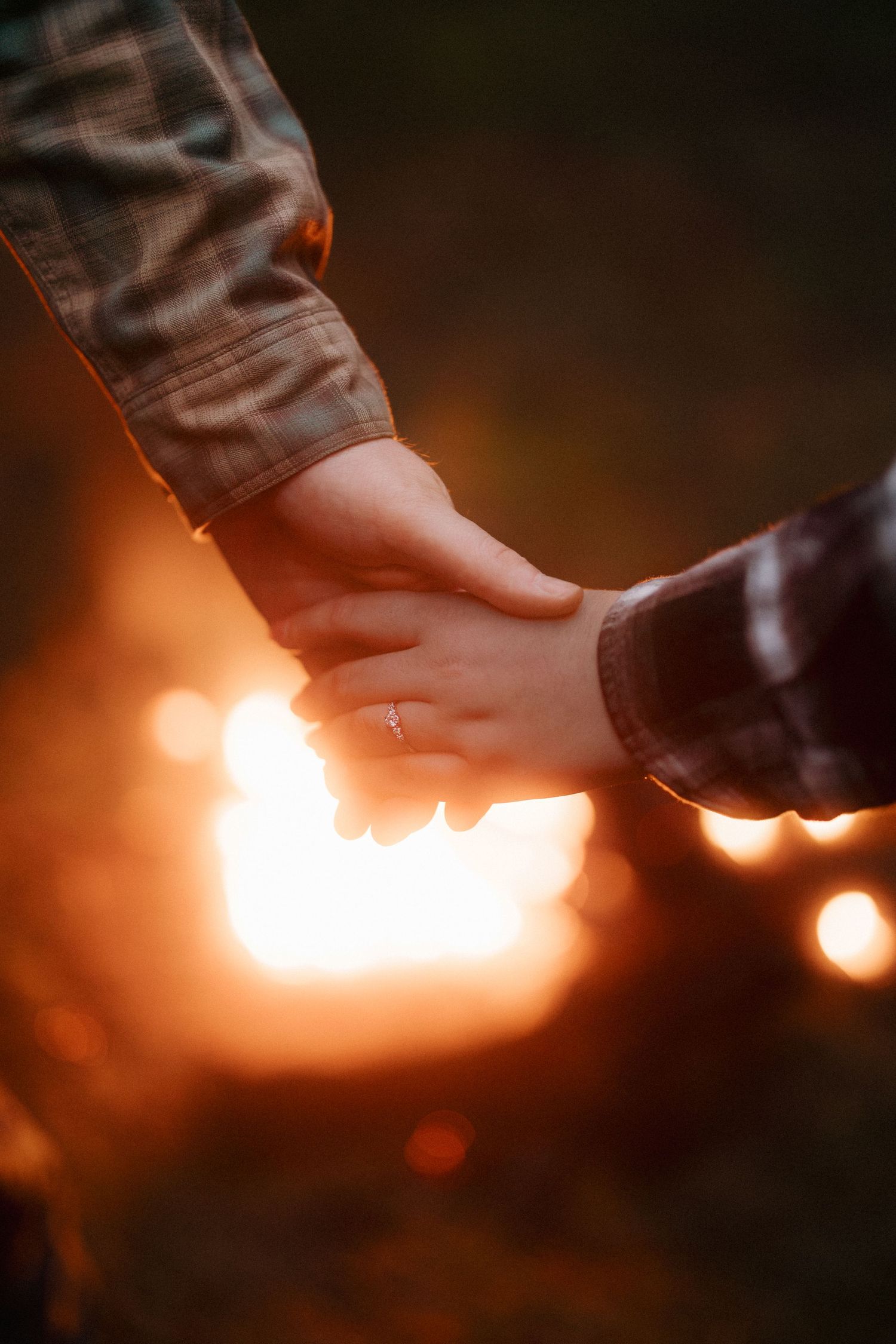Close-up shot of sparklers being lit against a dark background creating a warm glowing effect.