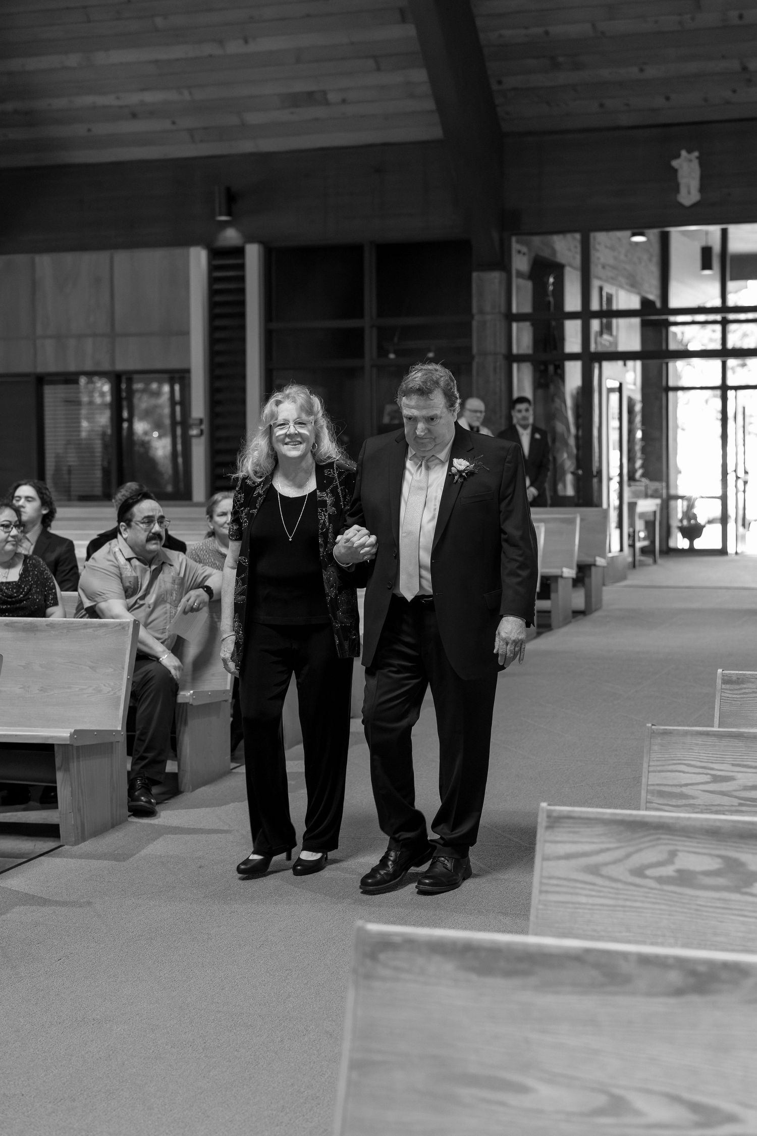 Black and white sequence showing dress shoes walking across a polished floor in a building lobby.