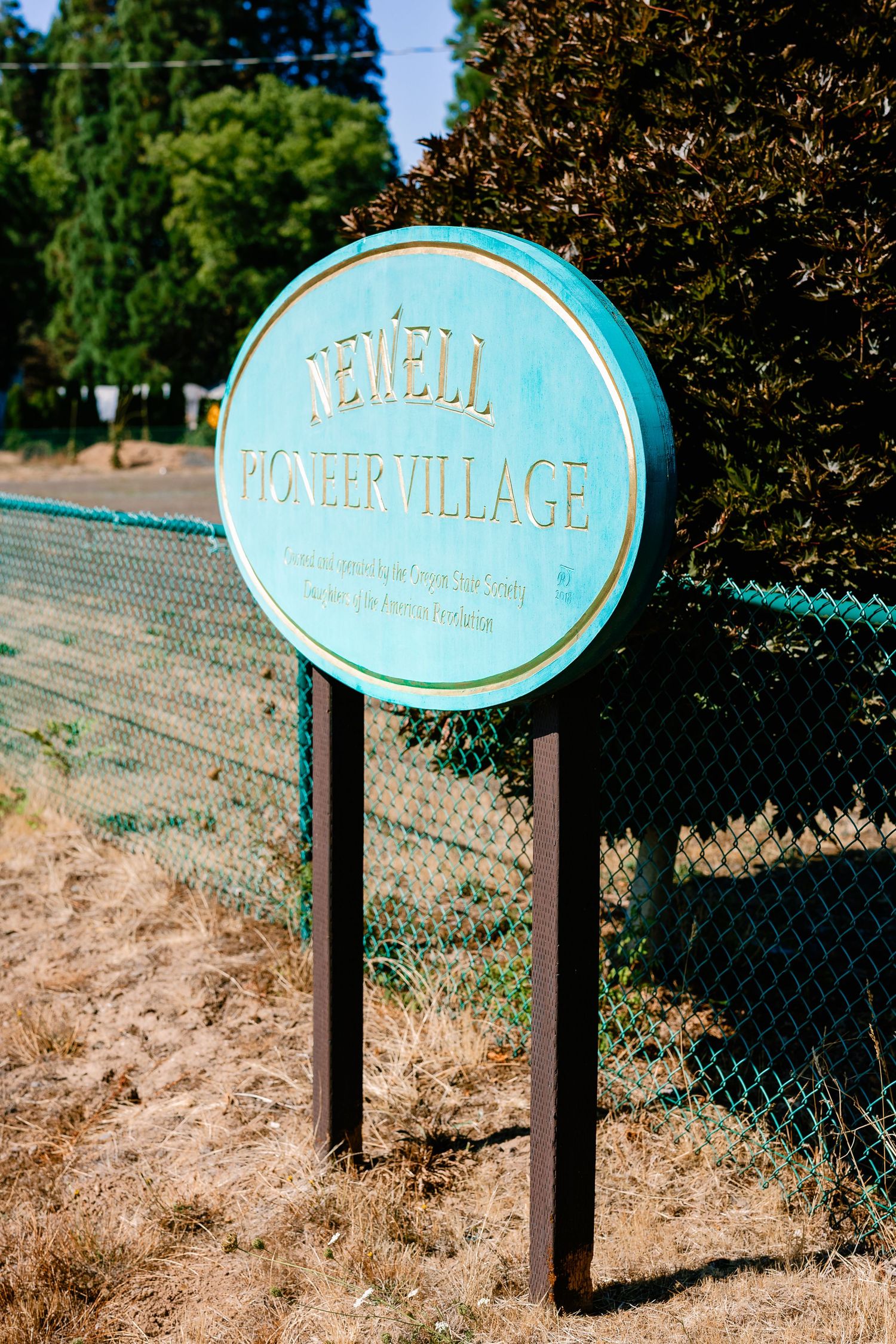 Vintage-style turquoise signs mounted on posts mark property boundaries.