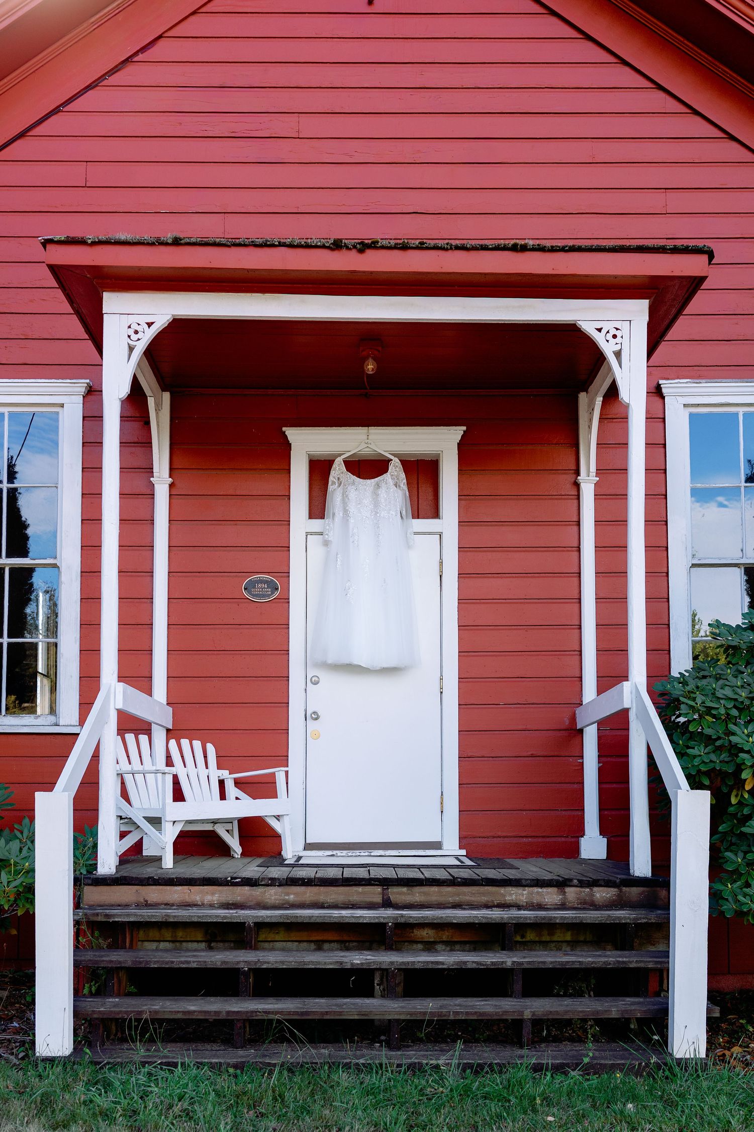 A red farmhouse-style building with white trim and a welcoming front porch.