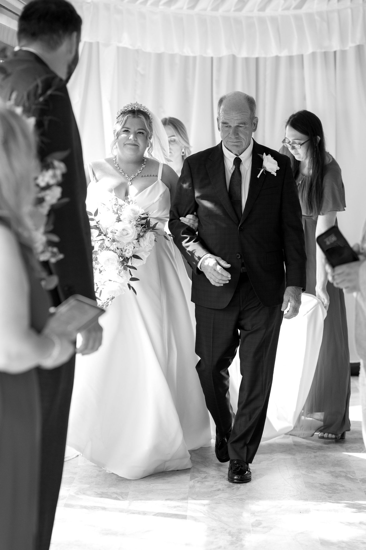 Black and white sequence of a wedding ceremony processional under an elegant white tent.