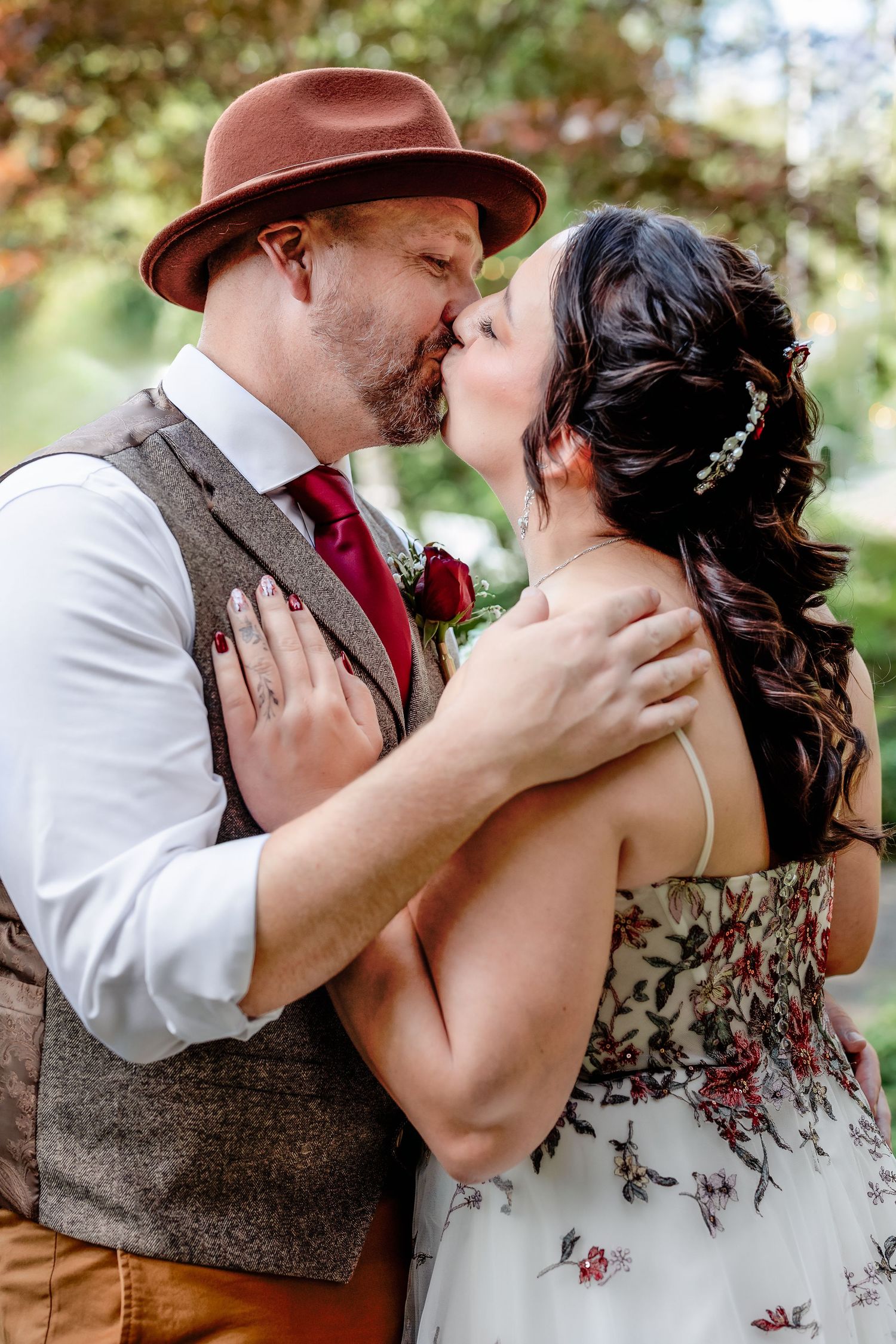 A tender romantic moment captured outdoors with vintage-inspired attire and natural lighting.