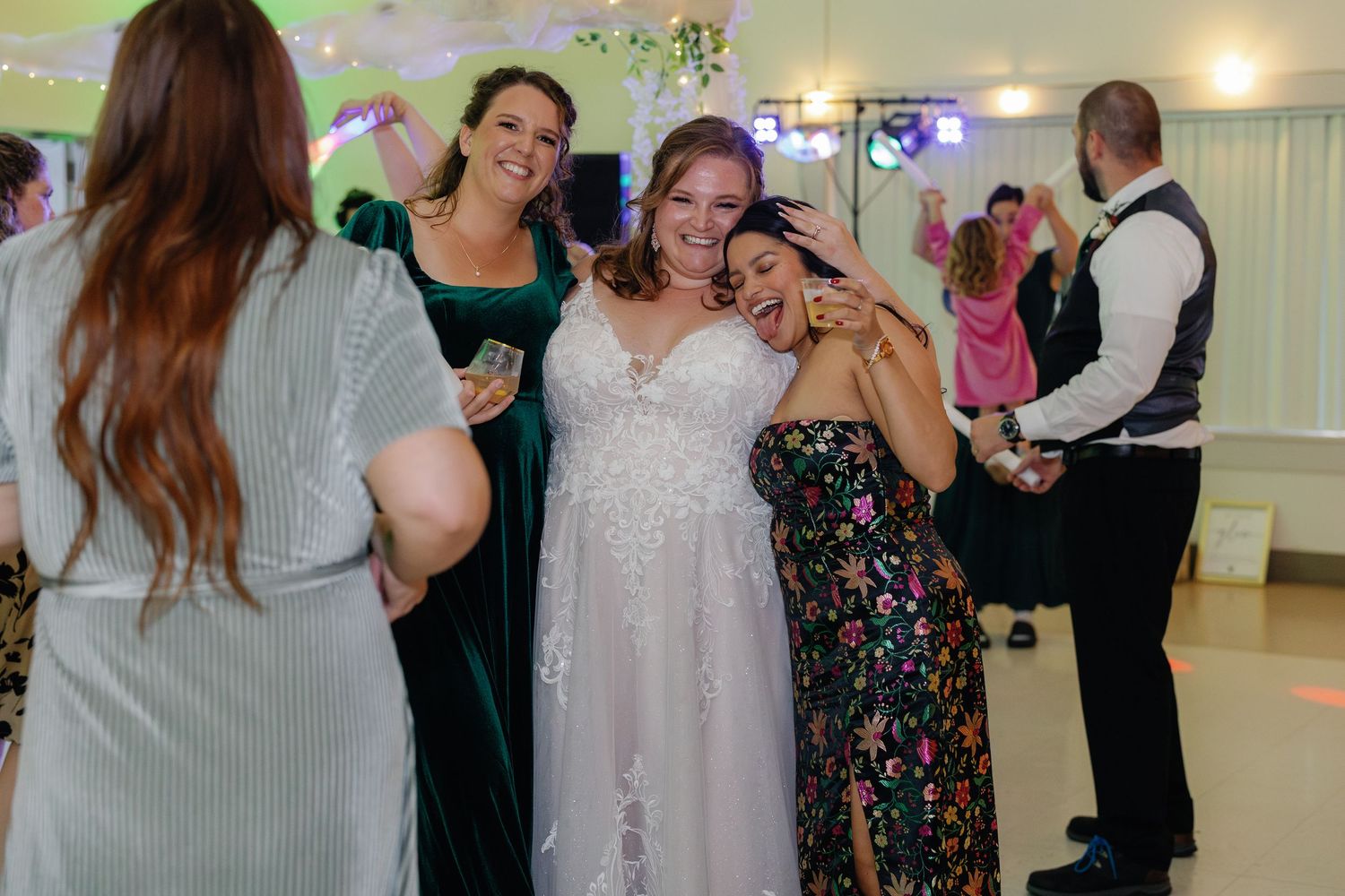 A group of friends share joyful moments during a wedding reception.