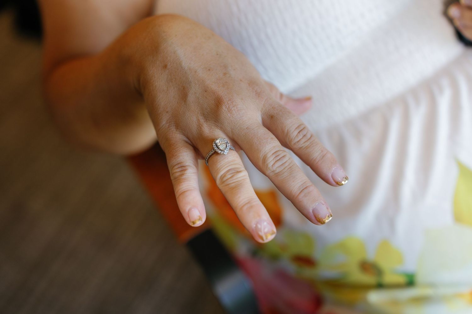 Close-up view of hands creating colorful nail art designs with polish and decorative elements.