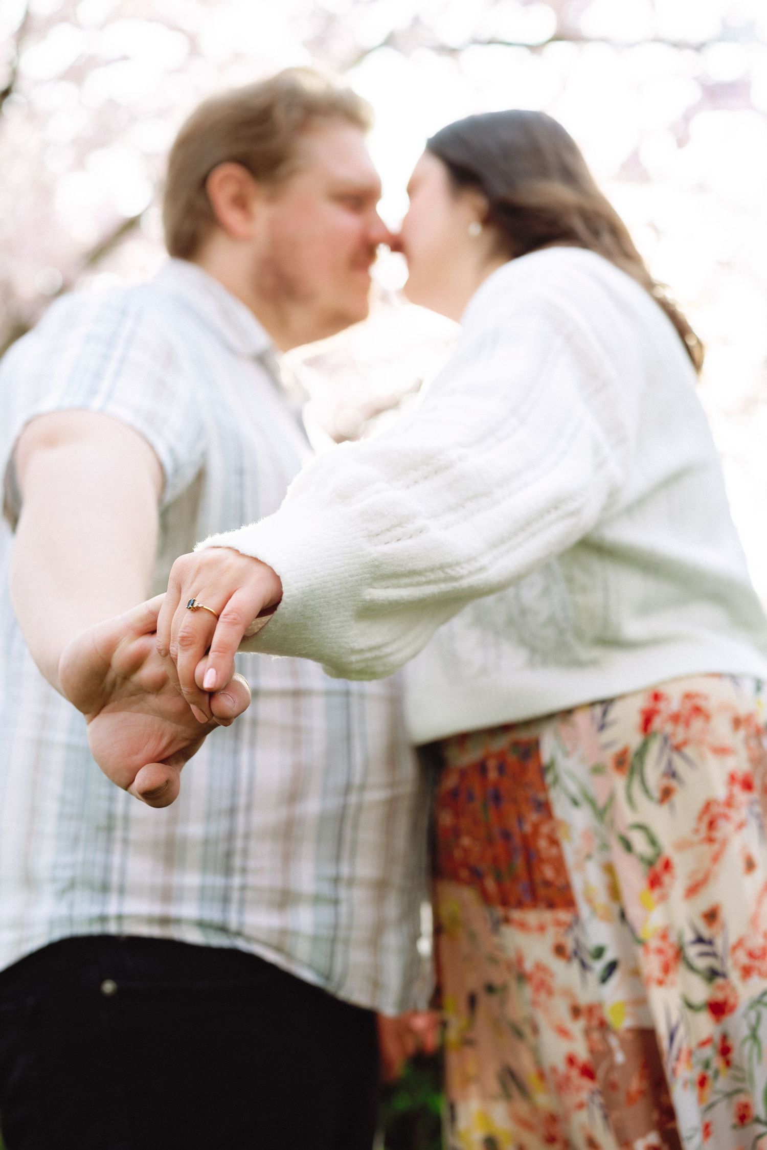 Close-up view of hands clasped together during a dance against a soft blurred background.