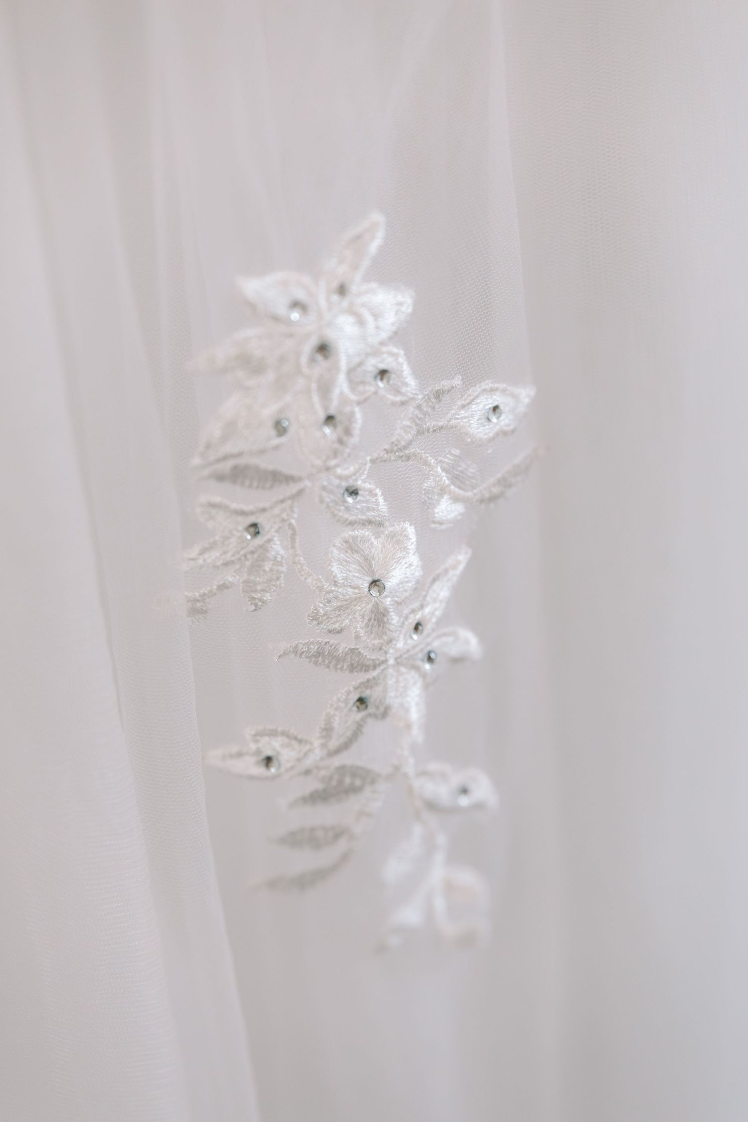 Delicate white crystal butterfly ornaments with sparkly details arranged in a soft dreamy composition.