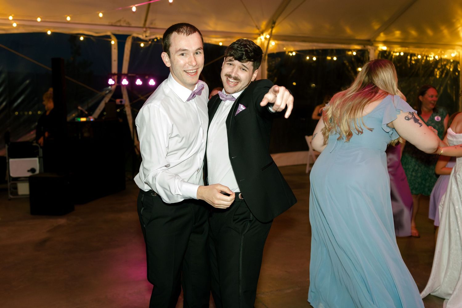 Wedding reception dance floor scenes under a tent with string lights creating warm ambiance.