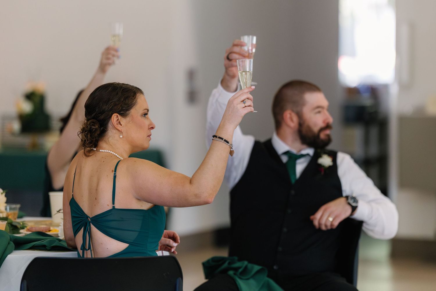 Wedding guests dancing and celebrating at a reception with people in formal attire.