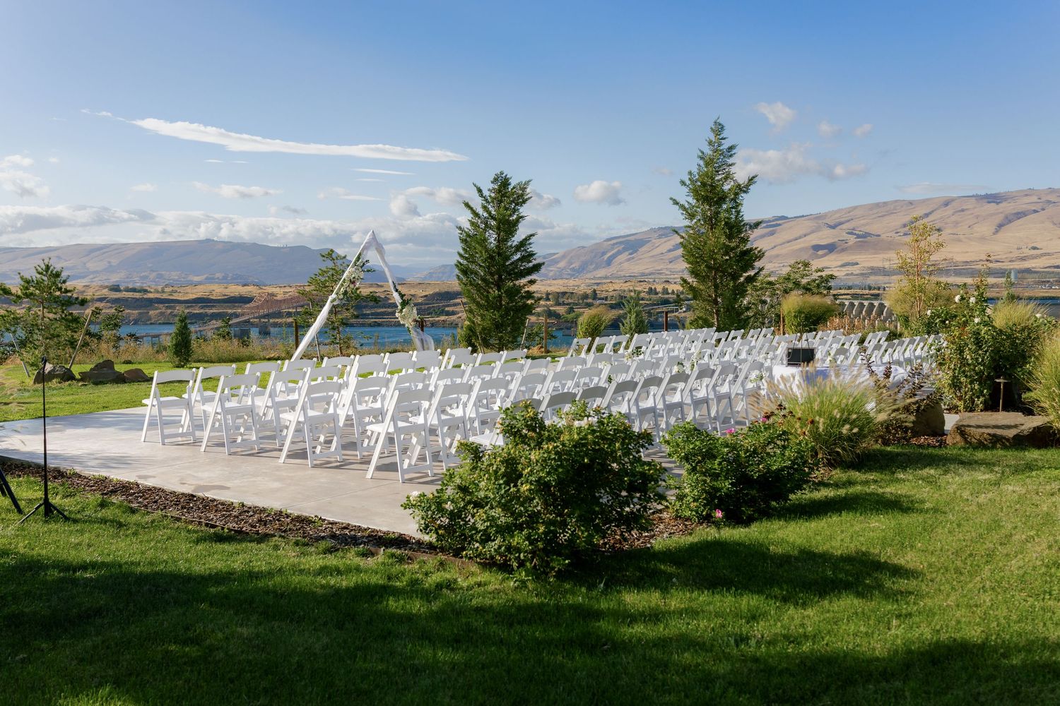 White chairs set up for an outdoor wedding ceremony with mountain views in the background.