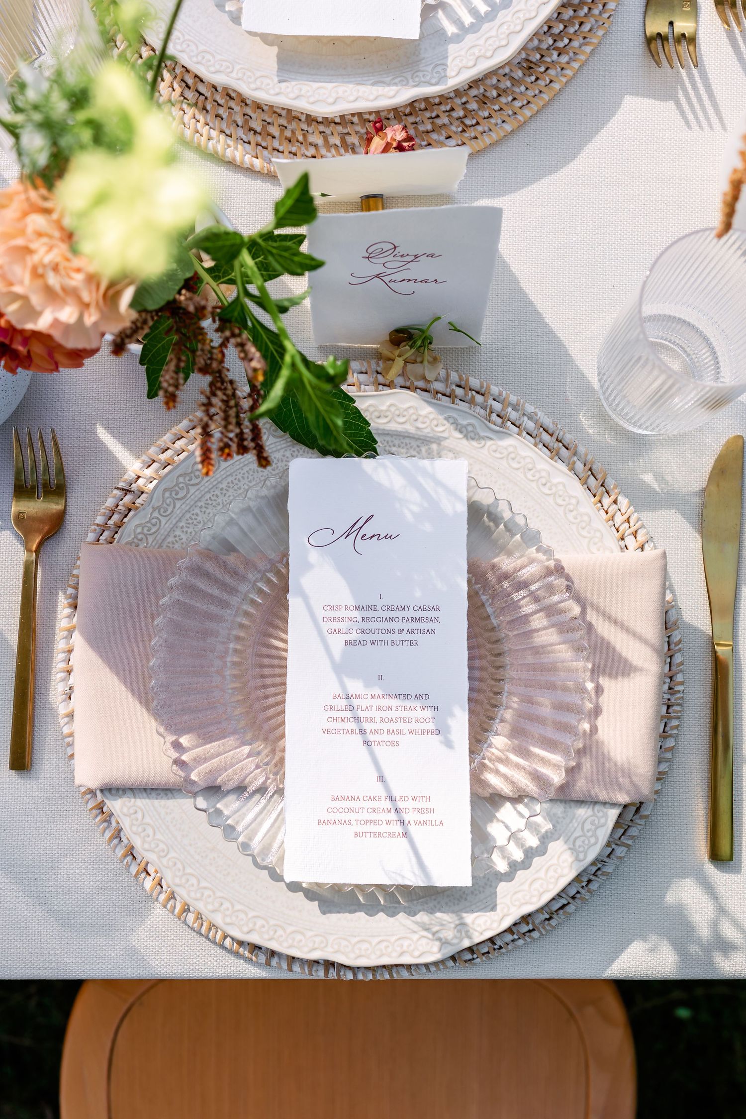 Elegant table setting with beaded charger plates, white napkins, and menu cards in soft natural lighting.