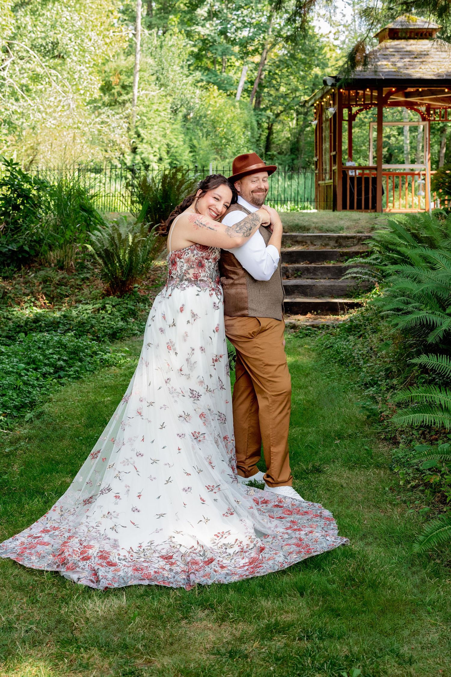 Wedding photos in a garden setting featuring a floral dress with flowing train.