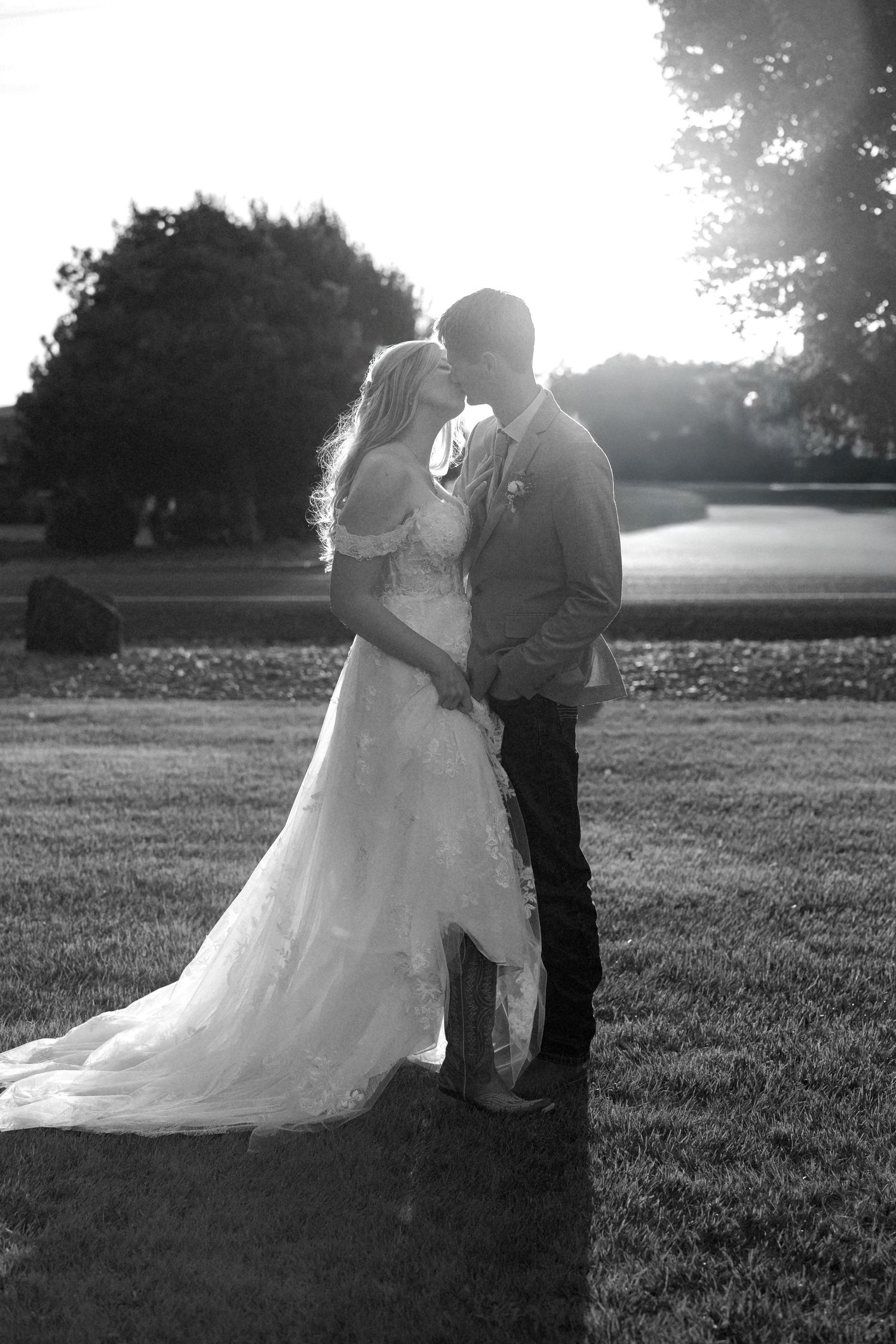A romantic black and white photo sequence showing a couple embracing in a grassy field at sunset.