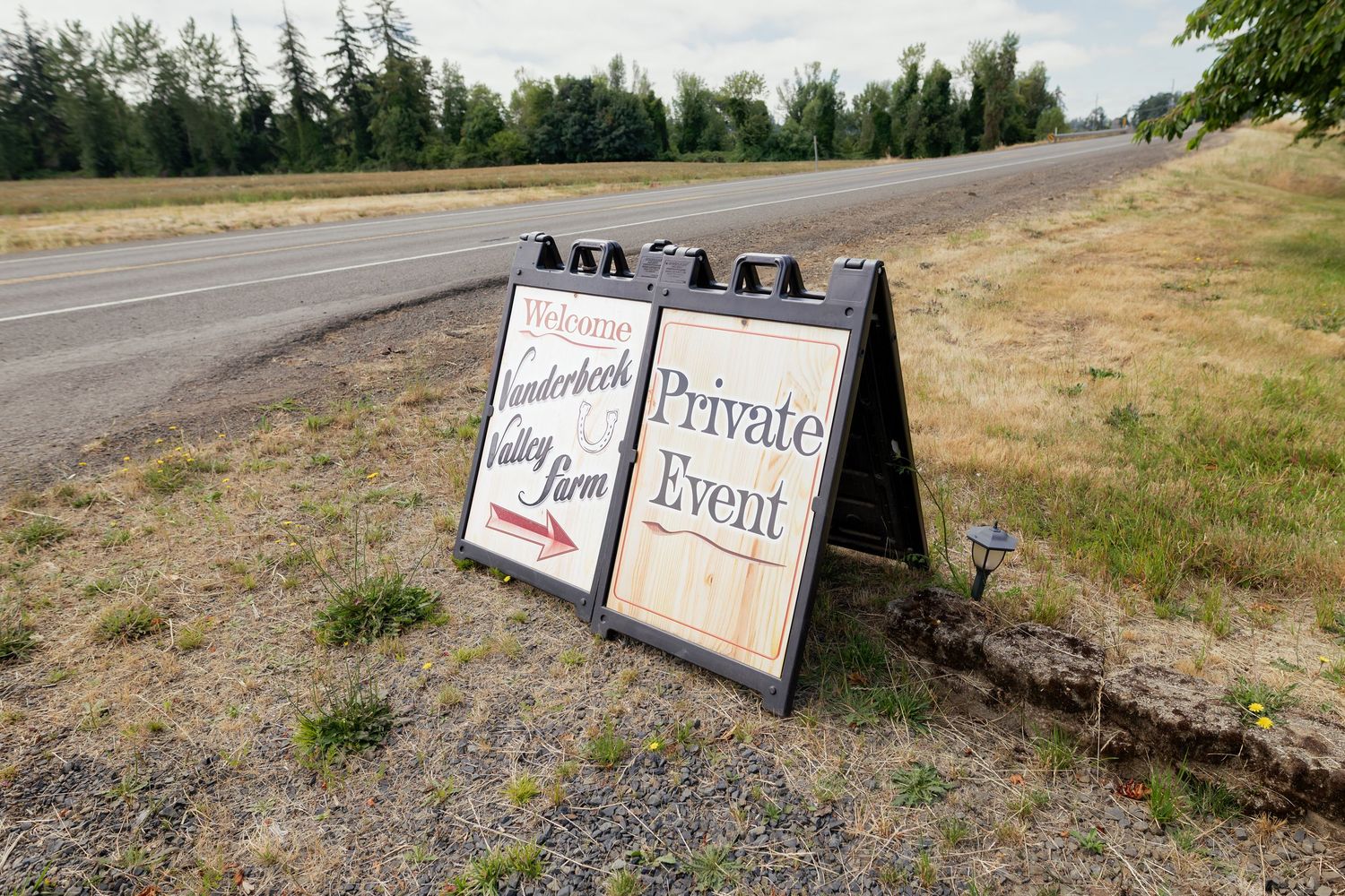 A-frame sandwich board signs for Vanderbeck Valley Farm private event placed roadside near a rural highway.