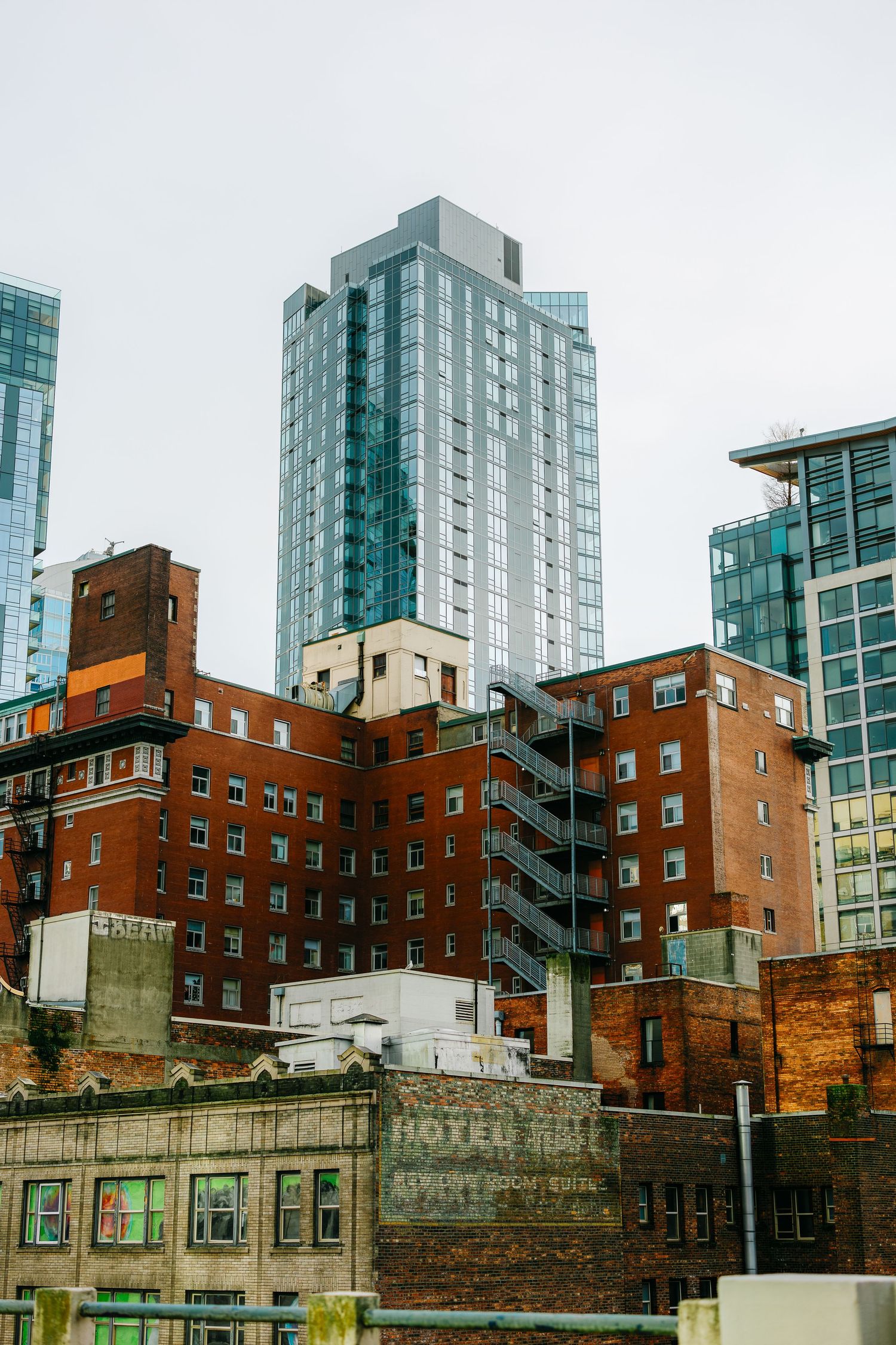 Urban landscape showing mix of historic brick buildings and modern glass skyscrapers in Seattle.