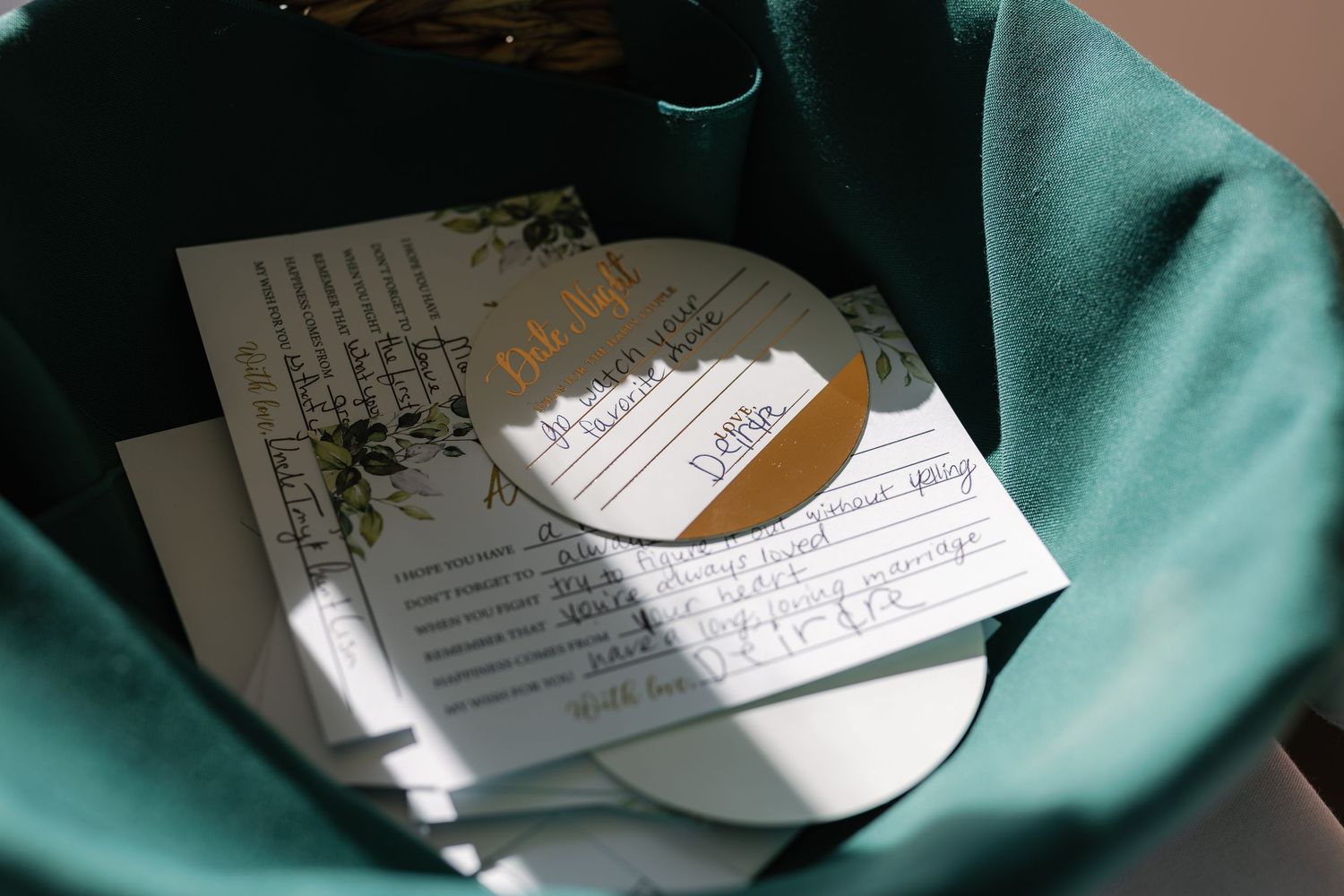 Sheet music and wedding program details in sunlight on teal fabric.