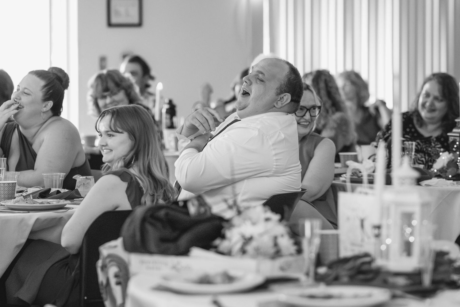 Wedding guests laugh and enjoy themselves during the reception celebration.