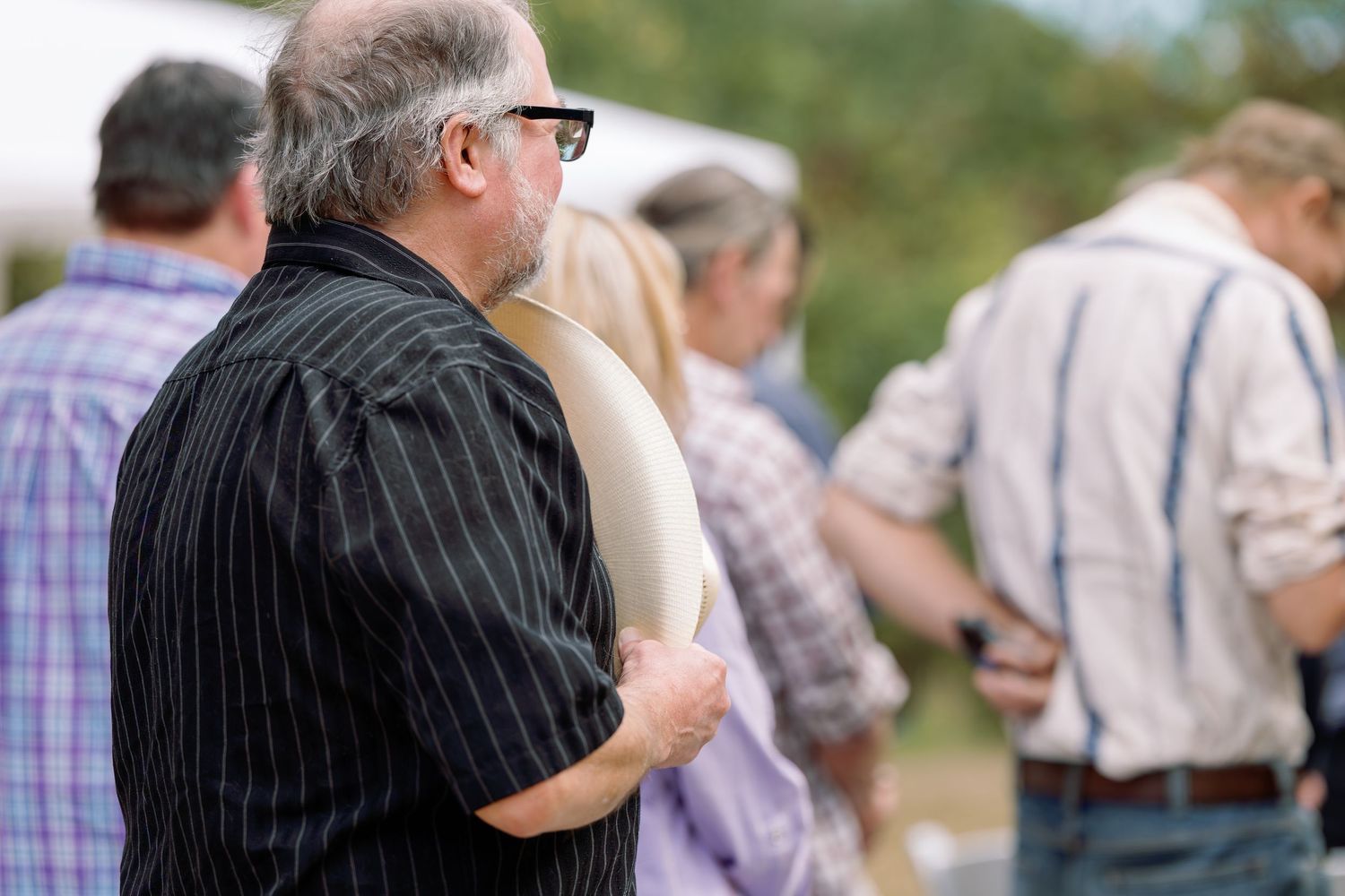 People dancing together outdoors in casual attire during a daytime social gathering.