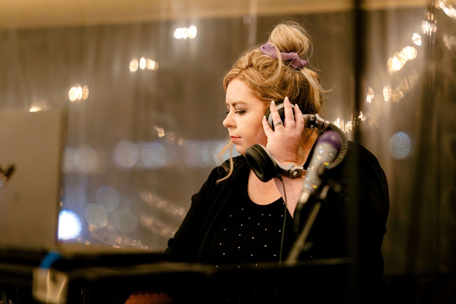 Musicians perform at a dimly lit wedding reception venue with string lights creating a romantic ambiance.