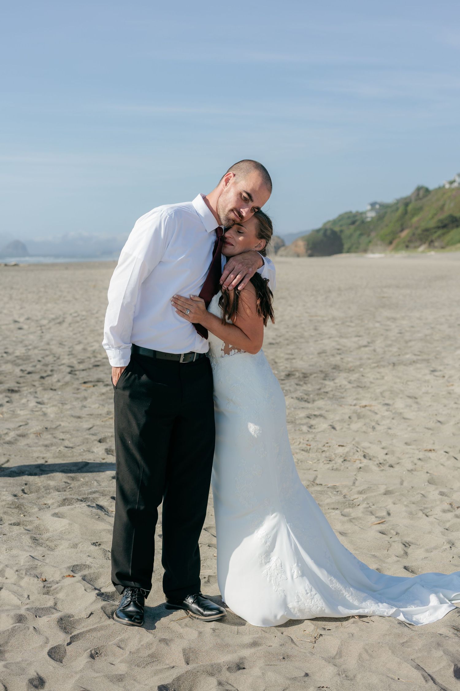 A joyful moment between newlyweds embracing on a sandy beach.