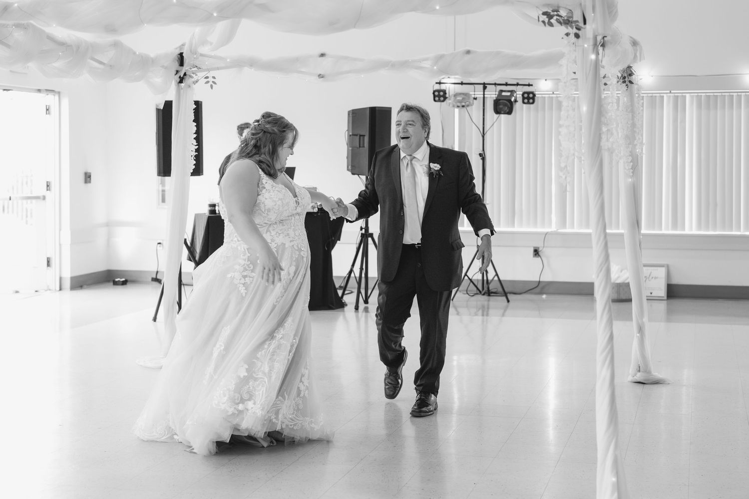 A couple dancing together in a bright indoor venue during a special celebration.