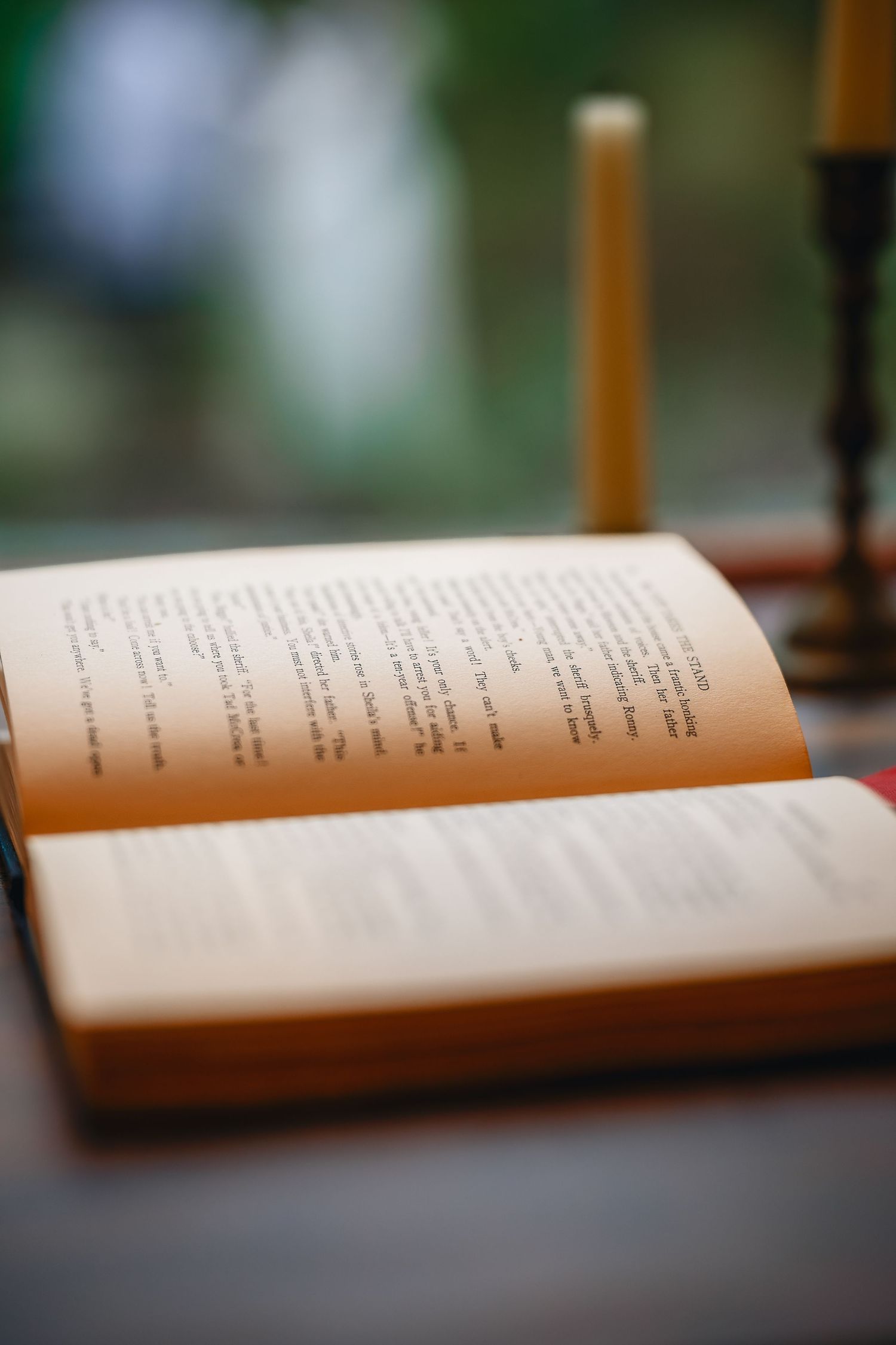 An open book with pages fanned out lies on a dark surface with shallow depth of field.
