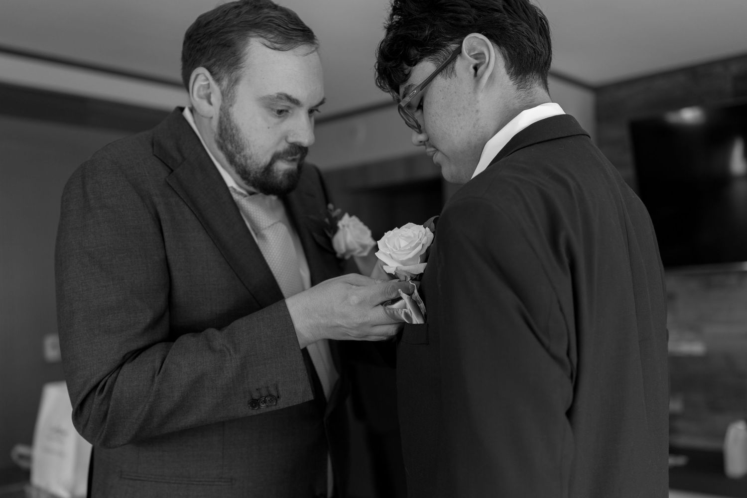 Black and white candid moment between wedding couple during ceremony.