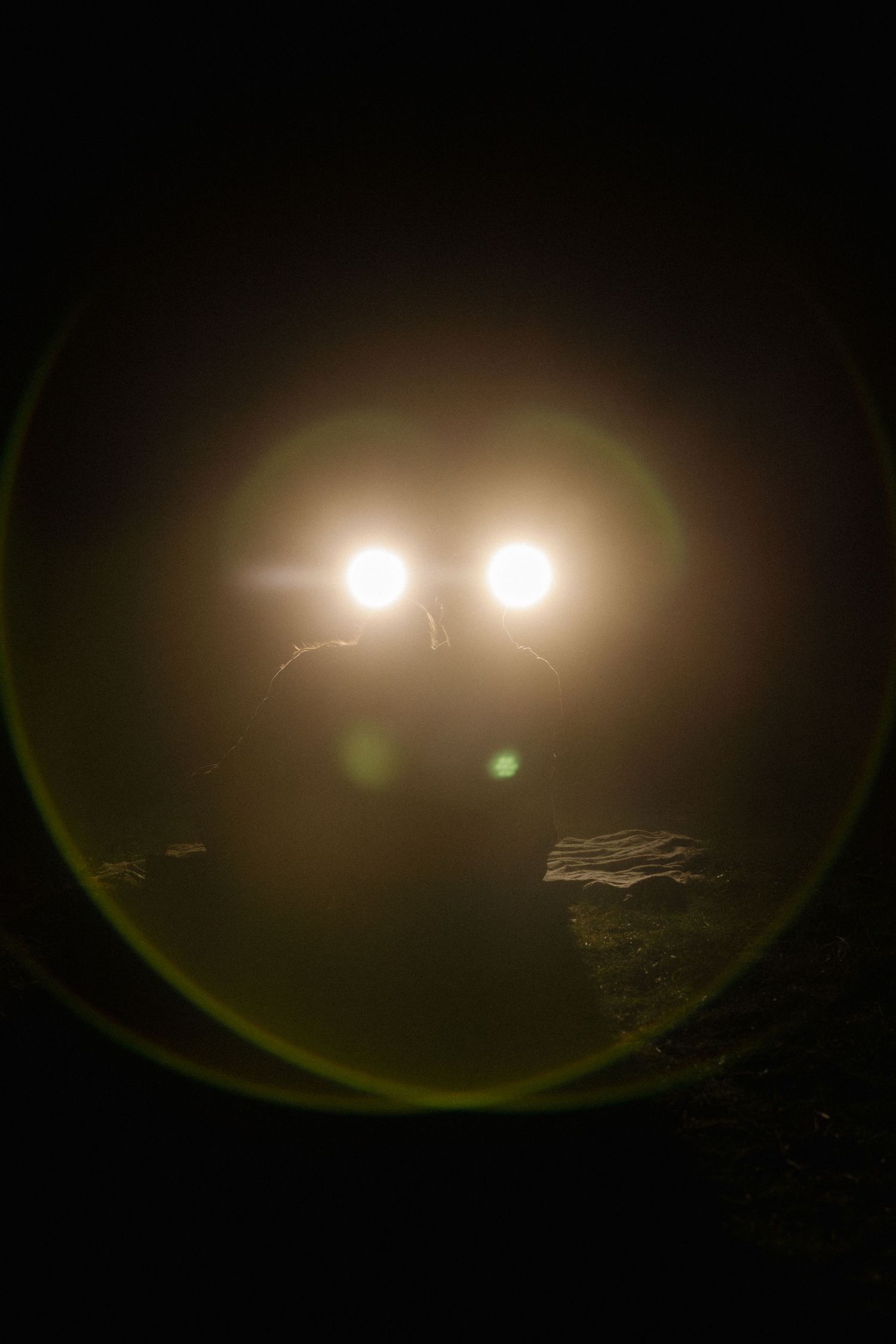 Night vision footage shows bright lights illuminating a dark landscape with varying levels of intensity.
