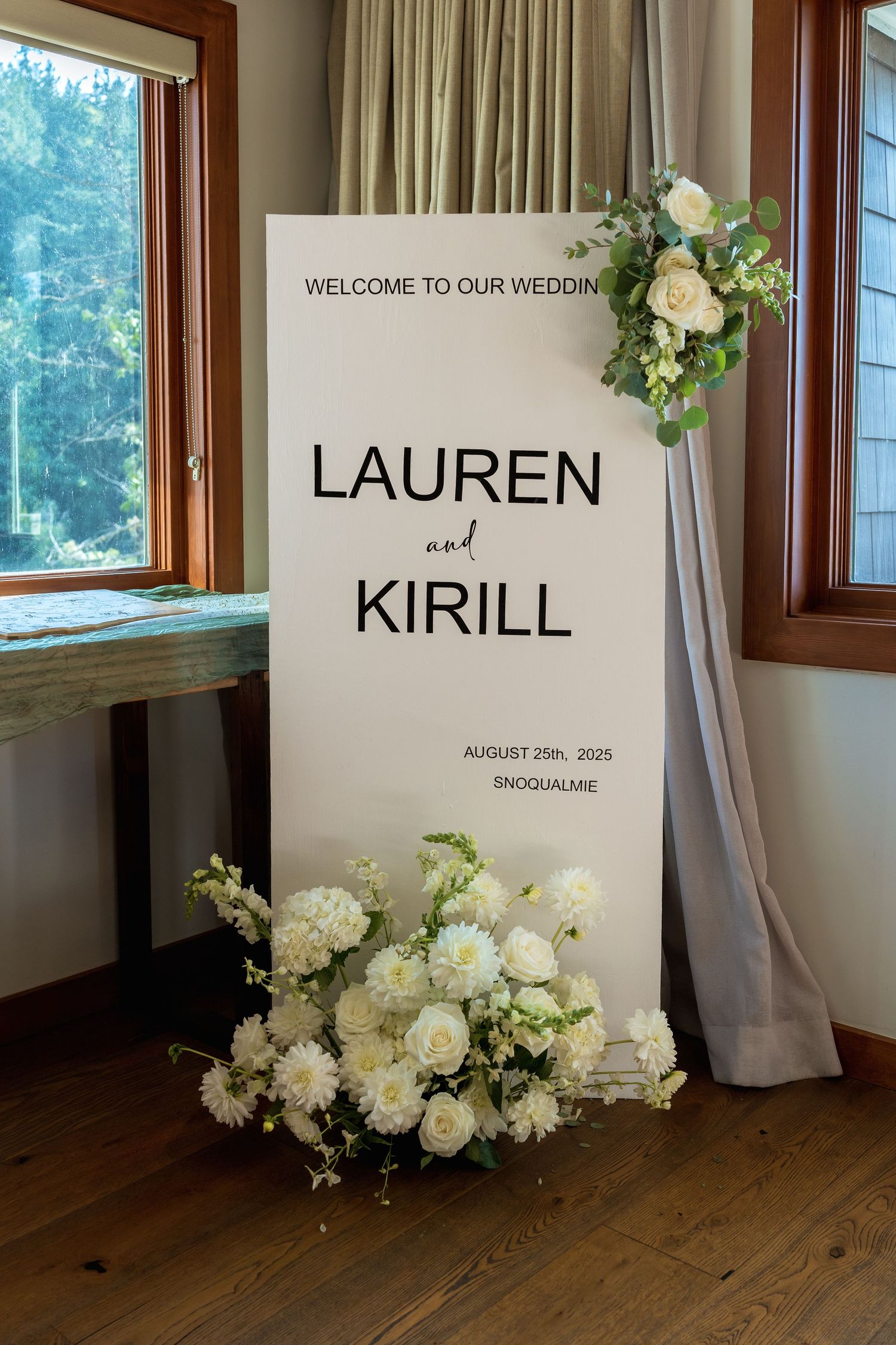 Modern minimalist wedding welcome sign with white floral arrangements.