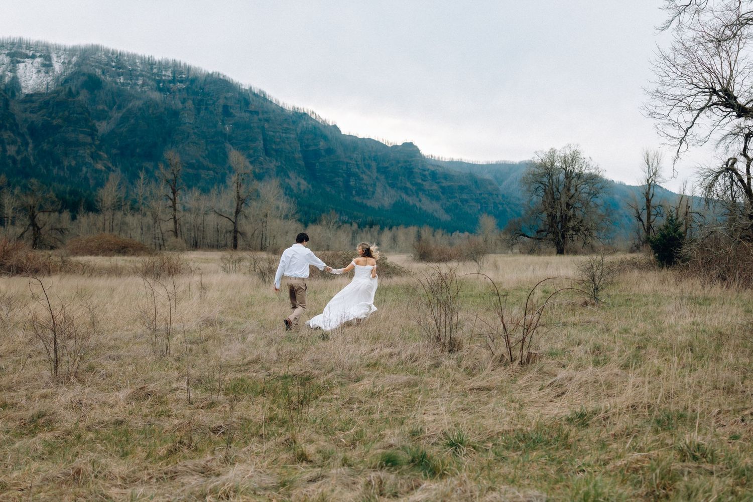 A romantic dance sequence captured in a meadow with mountains and bare trees creating a dramatic backdrop.