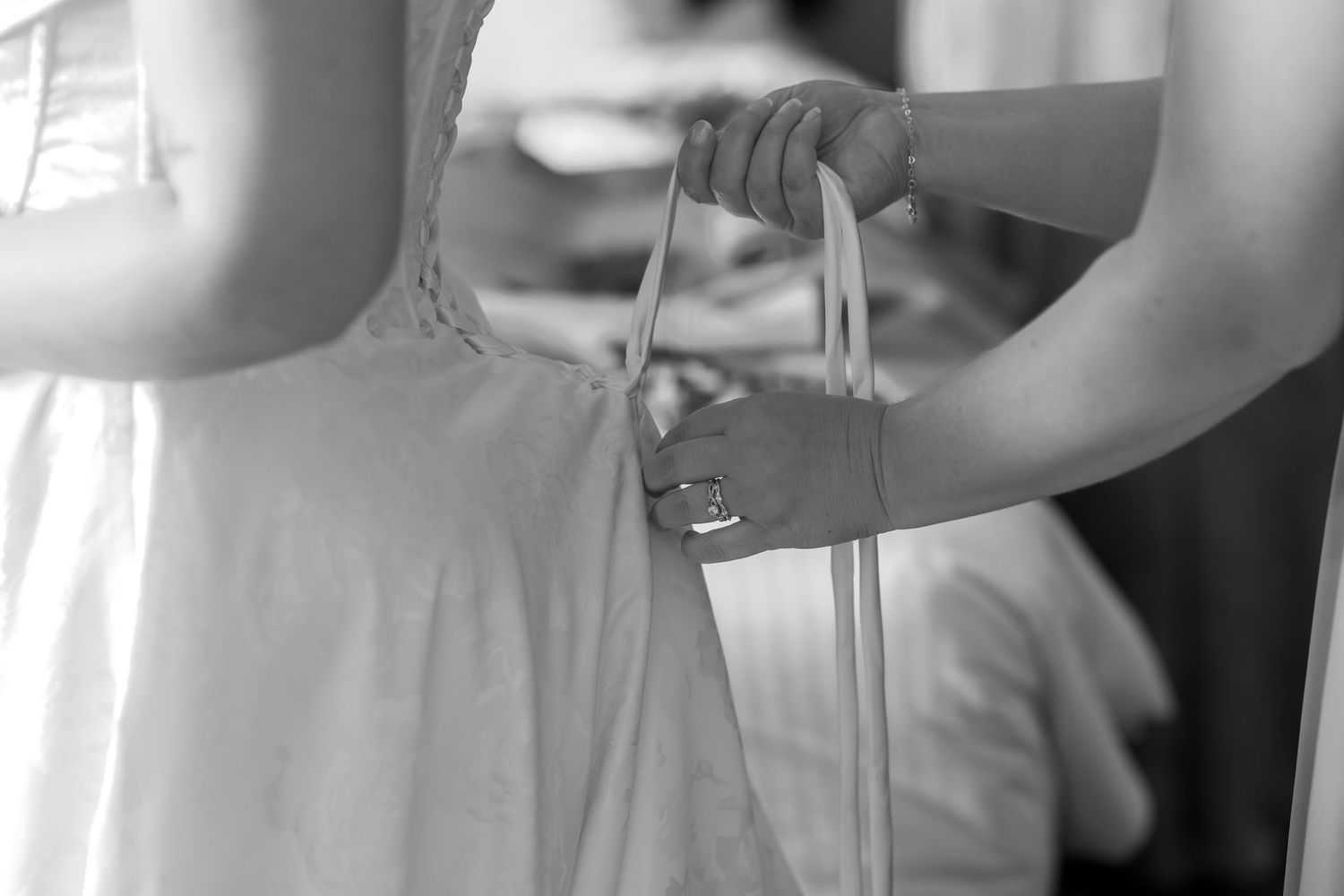 Close-up view of elegant wedding attire details including white dress fabric and formal wear.