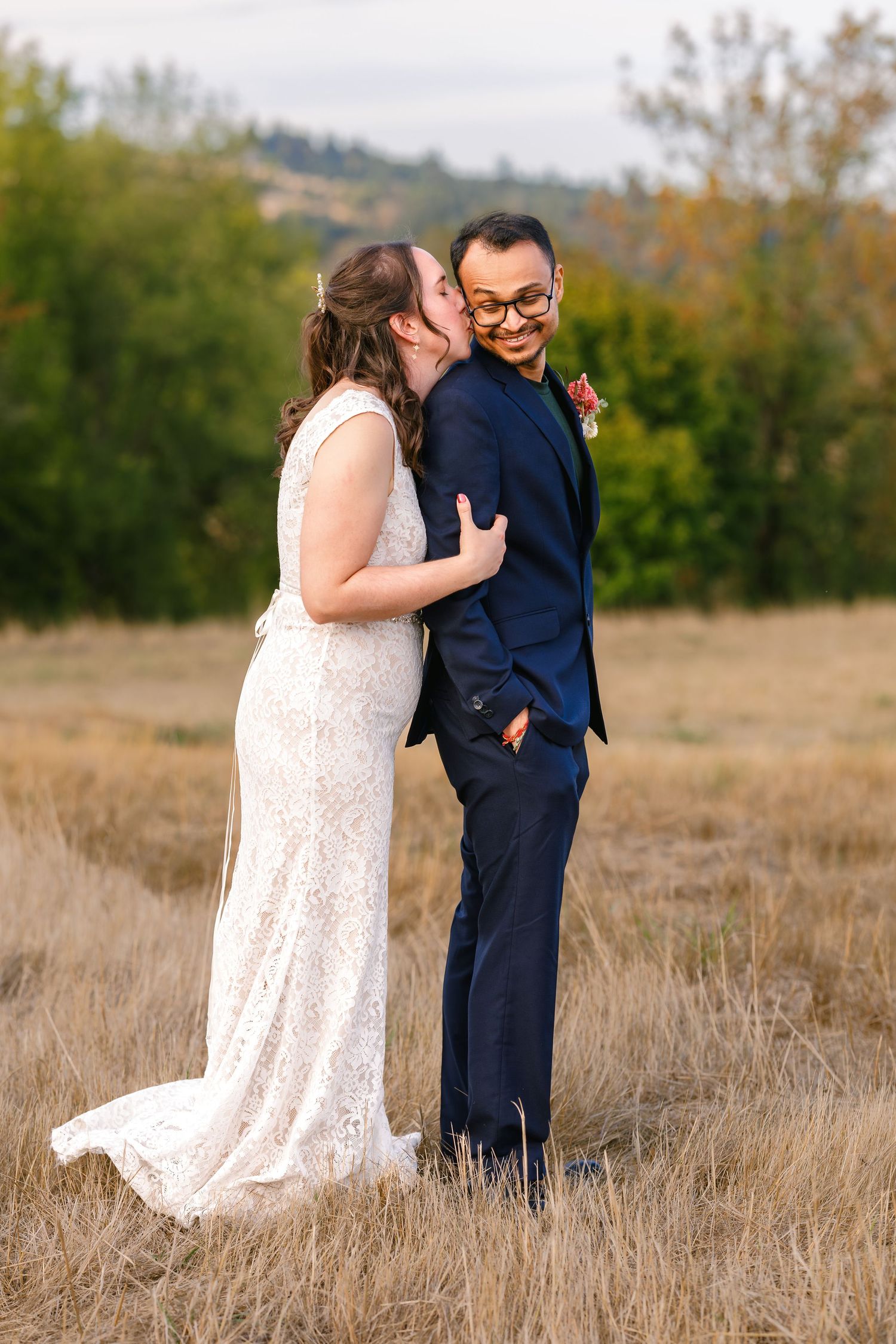Couple shares intimate moments in golden field during sunset wedding photoshoot.