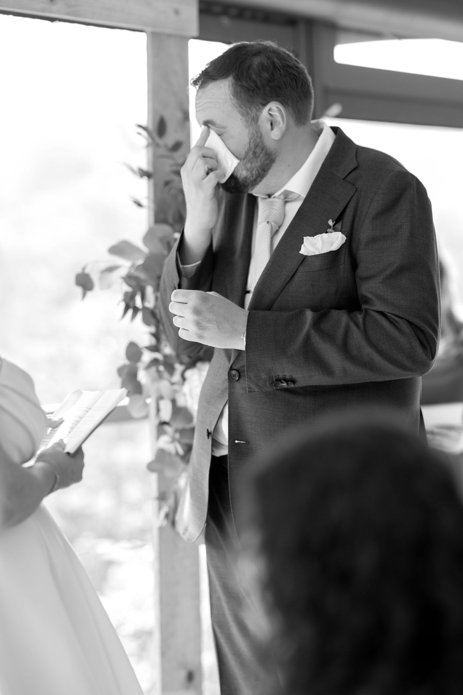 Wedding ceremony moment captured in black and white with emotional expressions.