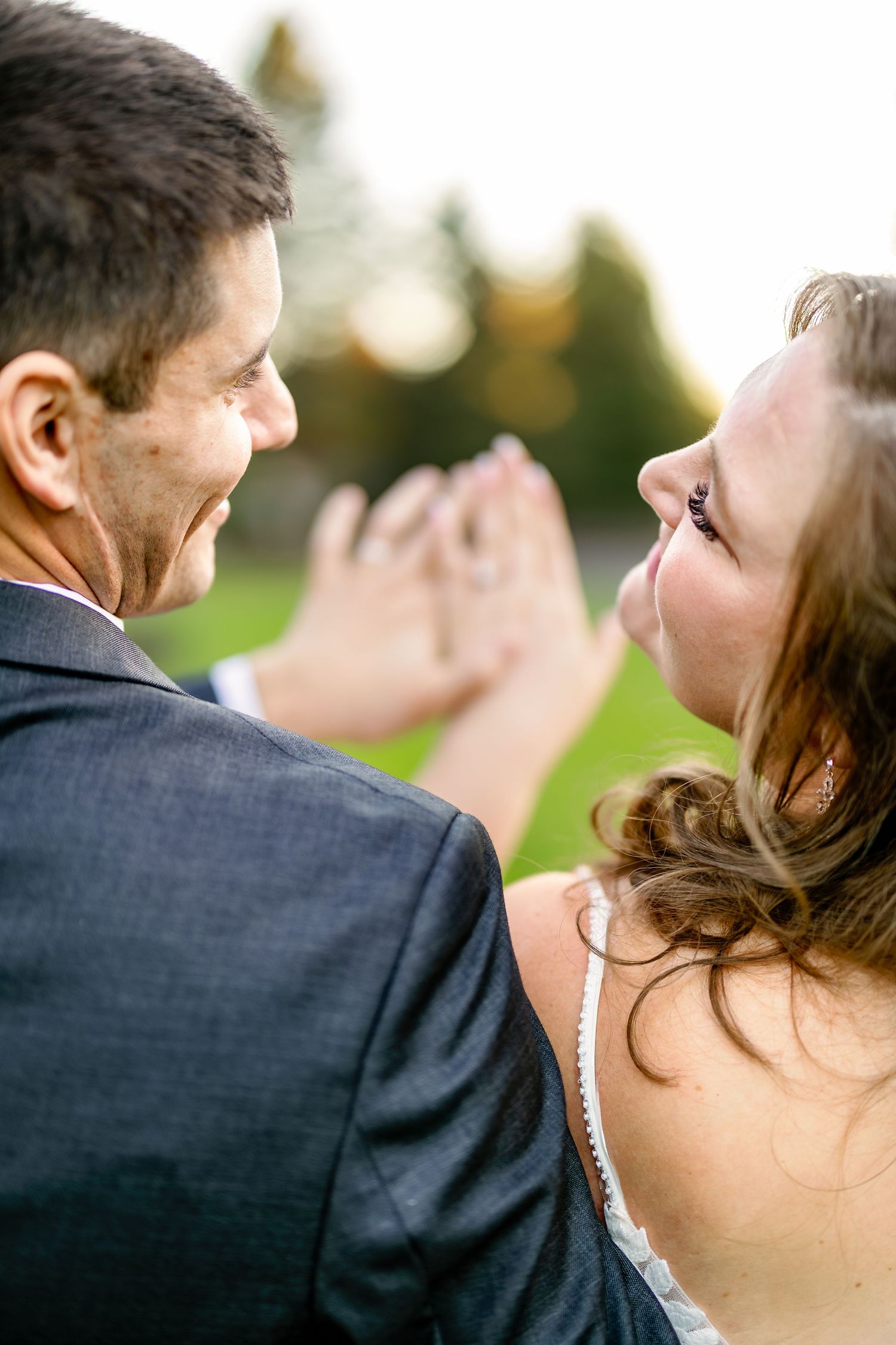 Close-up profile view of a couple sharing an intimate moment outdoors.