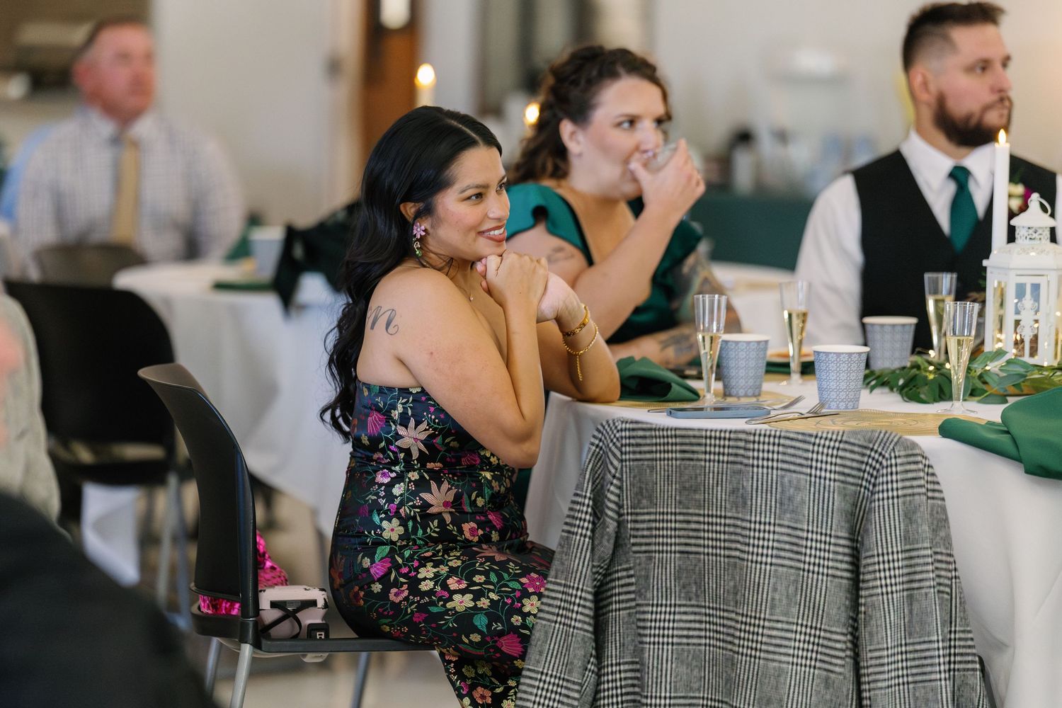 Wedding reception guests enjoying drinks and conversation at decorated tables.