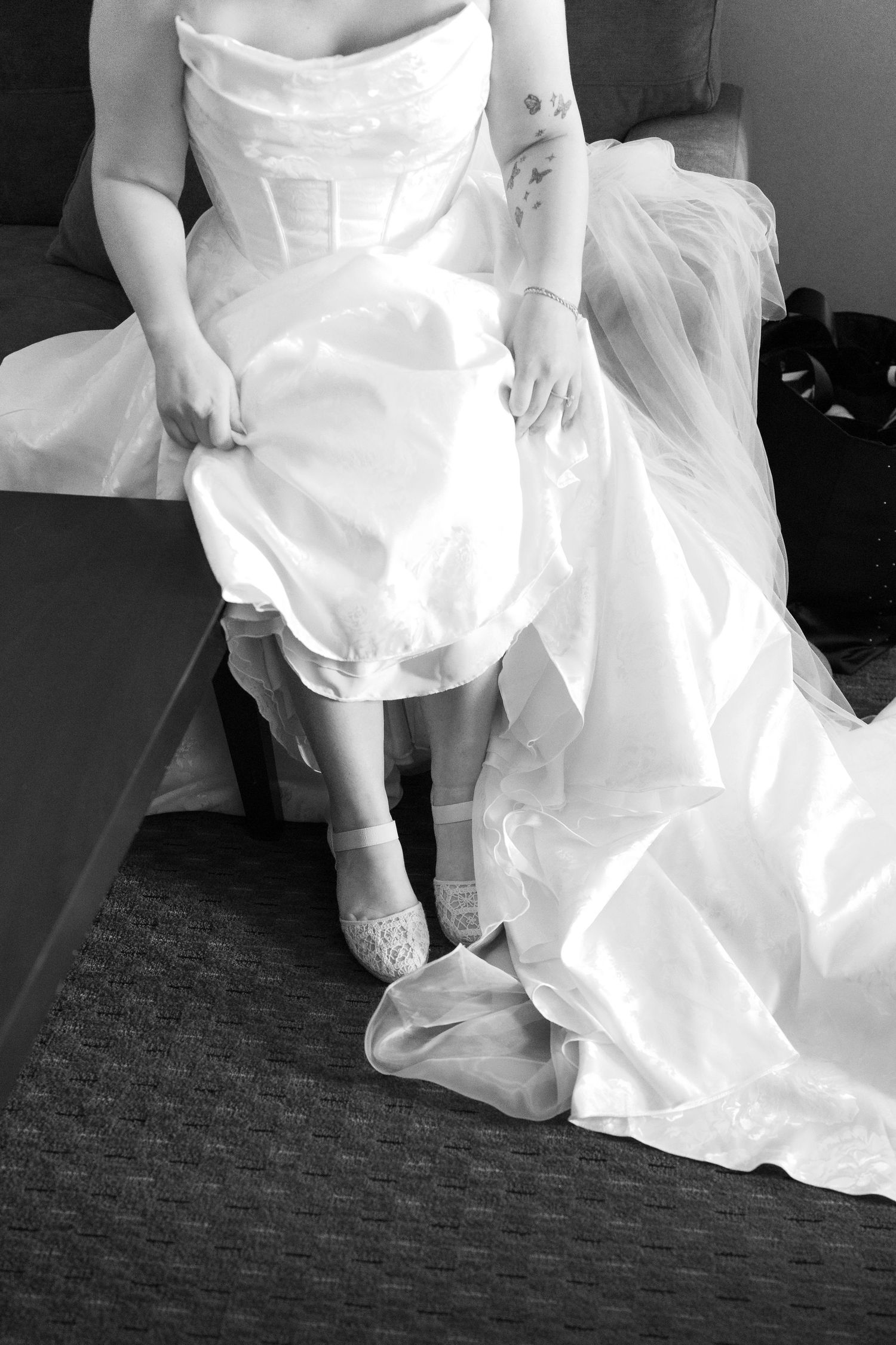 Close-up series of a white wedding dress and shoes on carpeted floor.