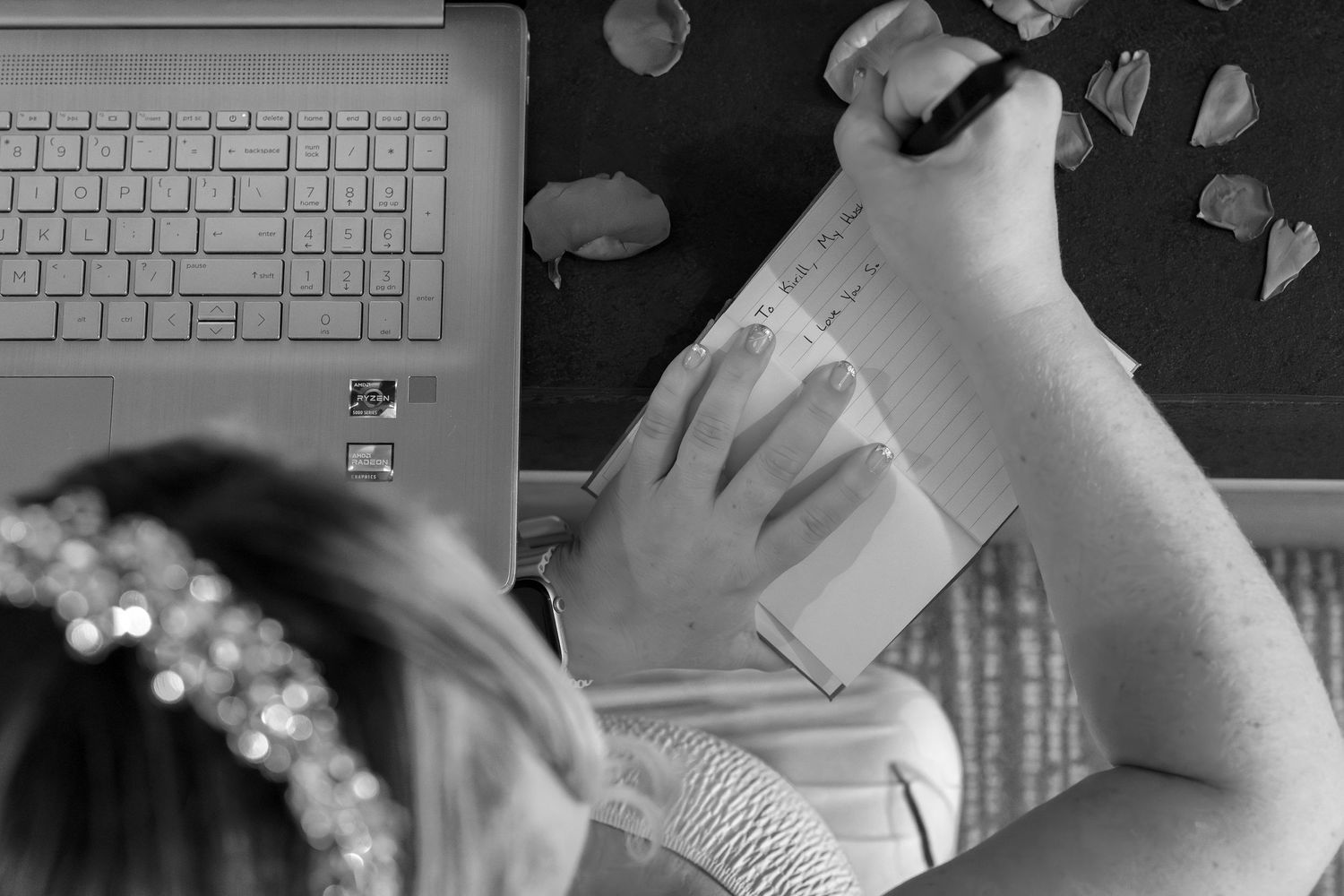 Person typing on a white keyboard with multiple monitors and office supplies on the desk in a modern workspace setup.