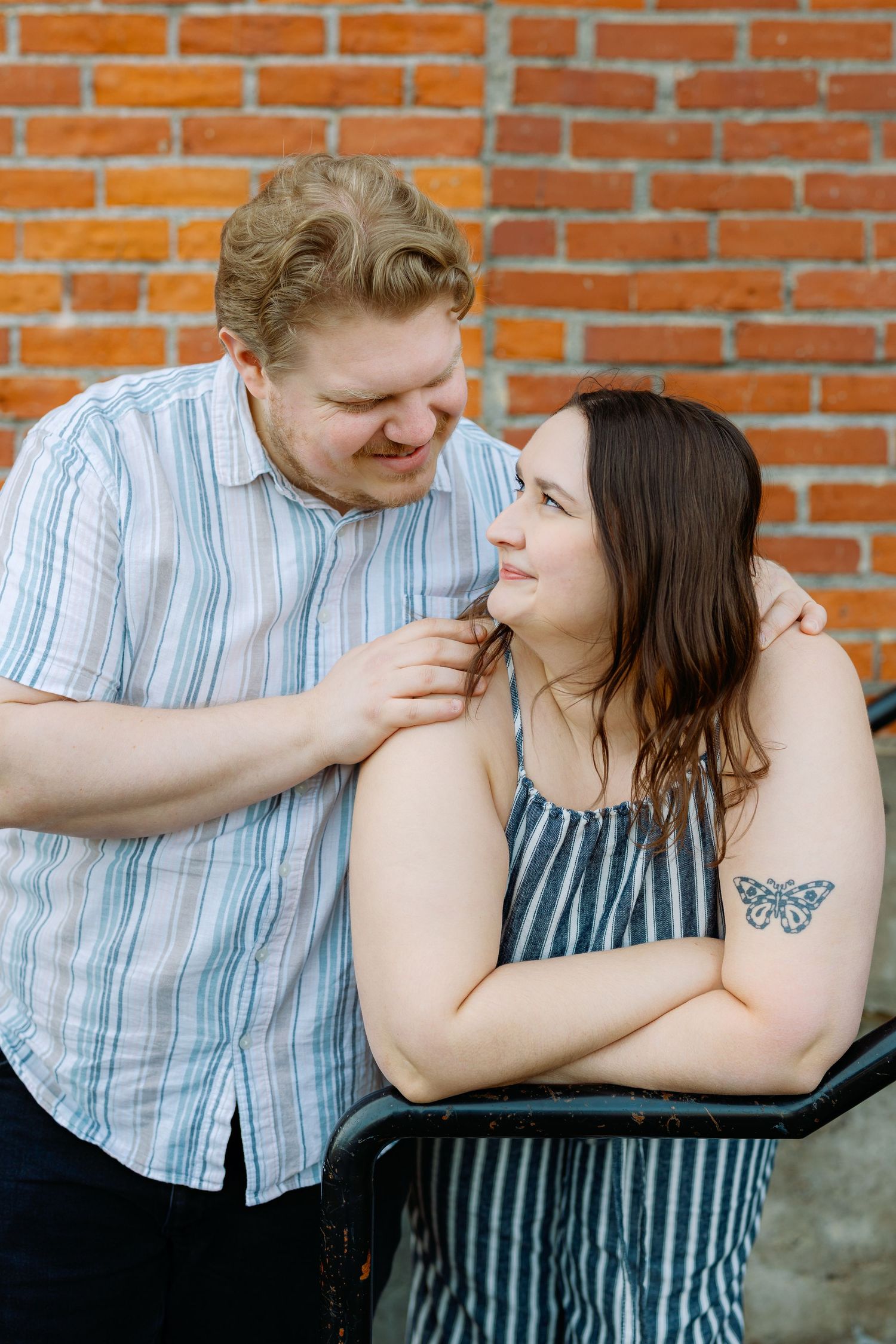 Tender moments between a couple captured in sequence against an orange brick wall backdrop.