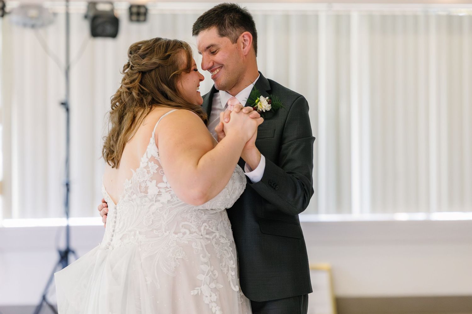A couple shares their first dance together at their wedding reception.