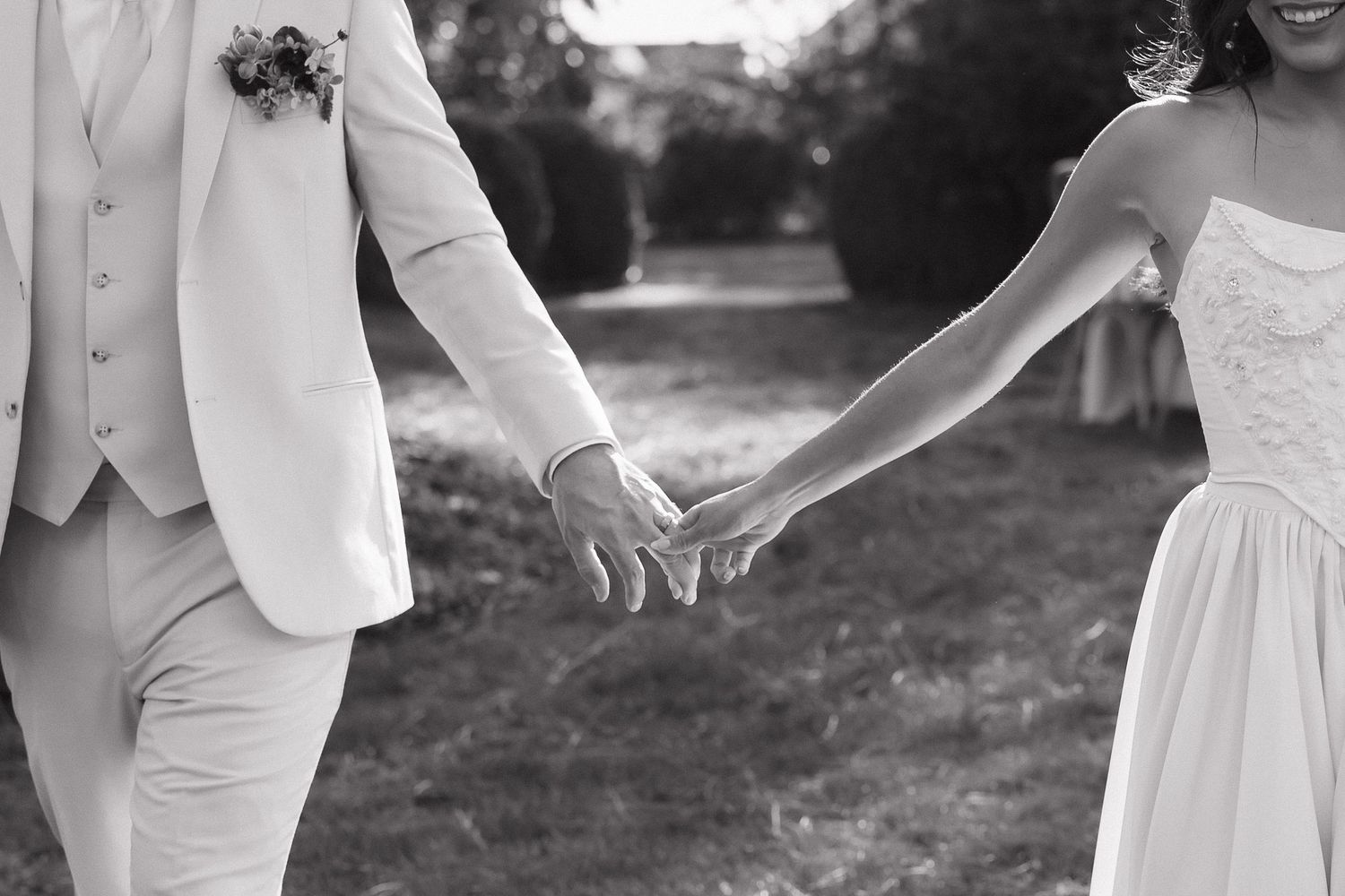 Bride and groom share an intimate moment in a garden setting wearing classic white wedding attire.