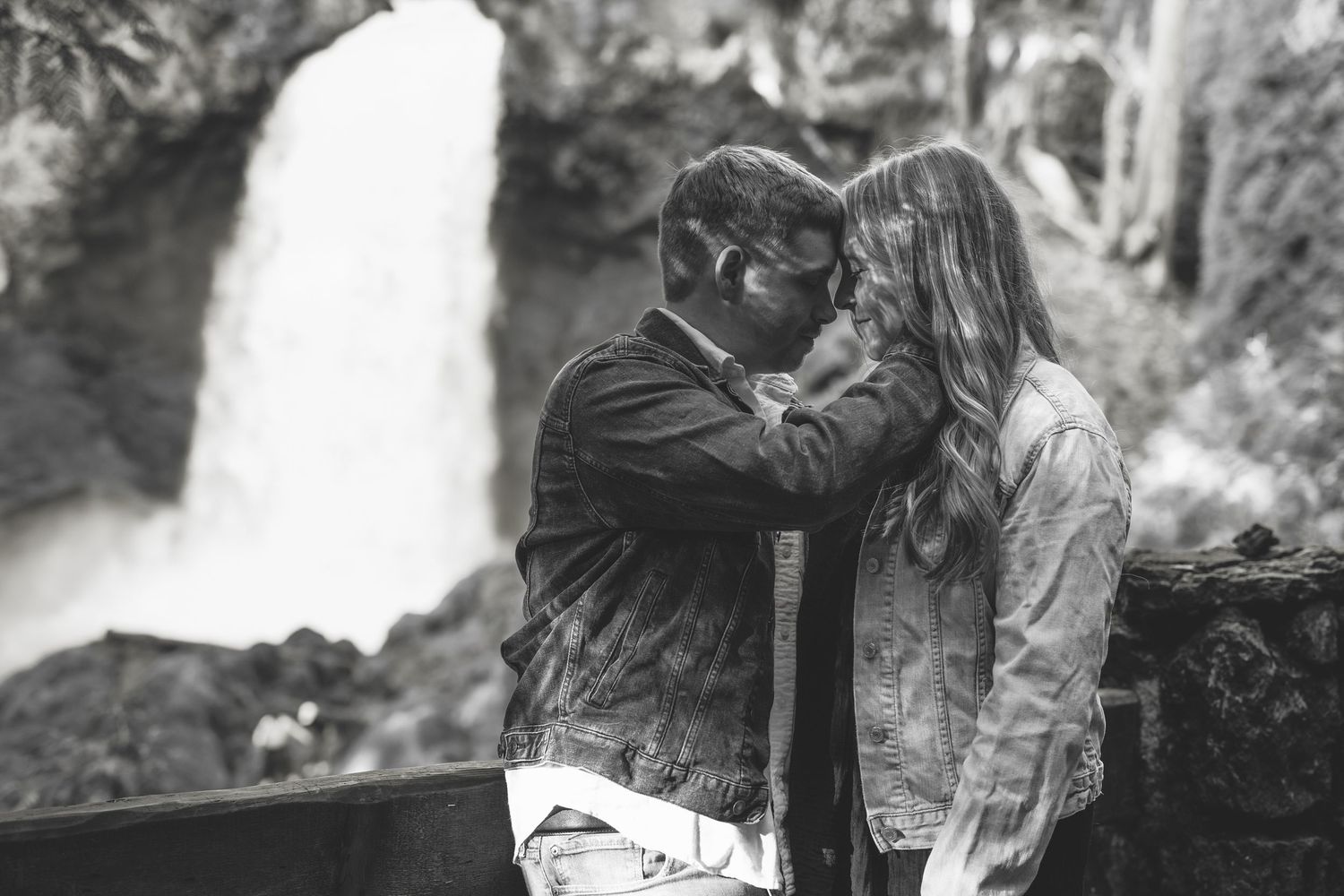 A black and white romantic moment captured with waterfall backdrop in nature.