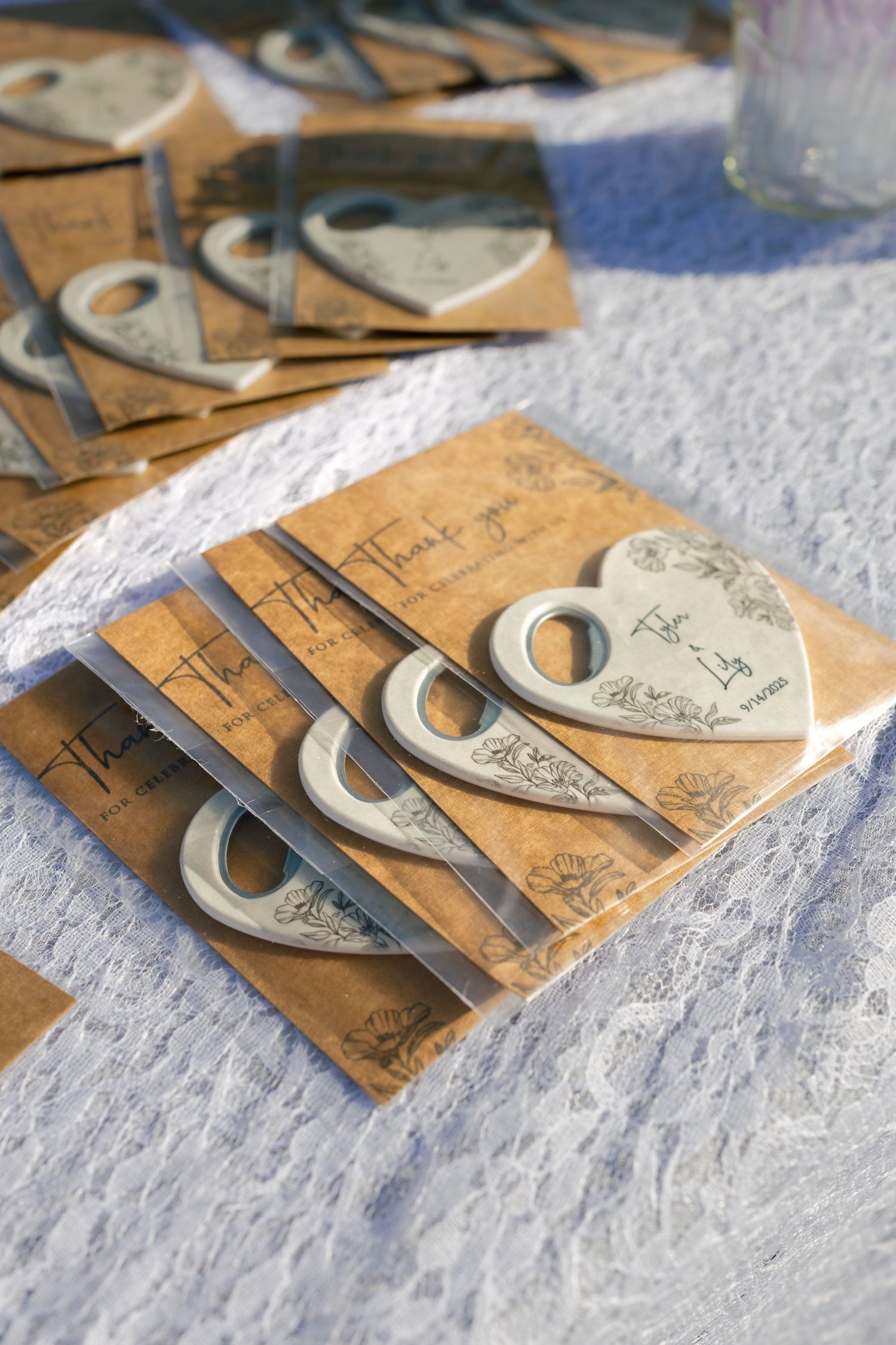 Vintage brown paper CD sleeves with handwritten text arranged on white lace fabric.