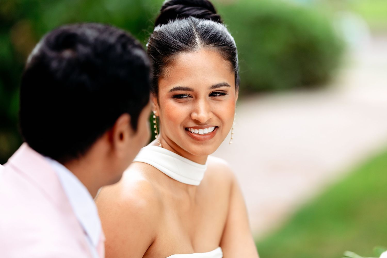 Couple sharing a joyful moment during their wedding celebration in a garden setting.