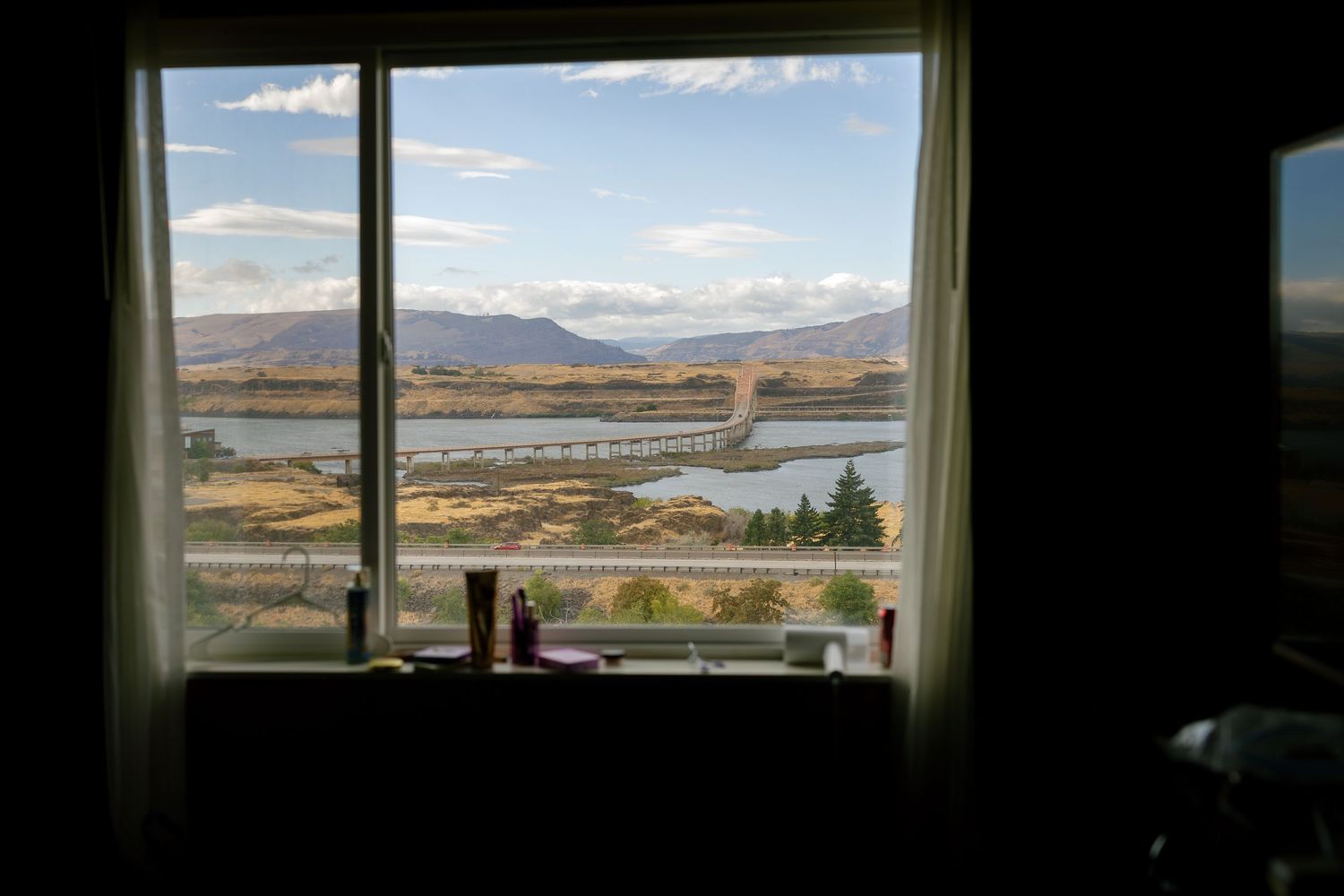 Panoramic mountain landscape view through a window showing scenic terrain and sky.
