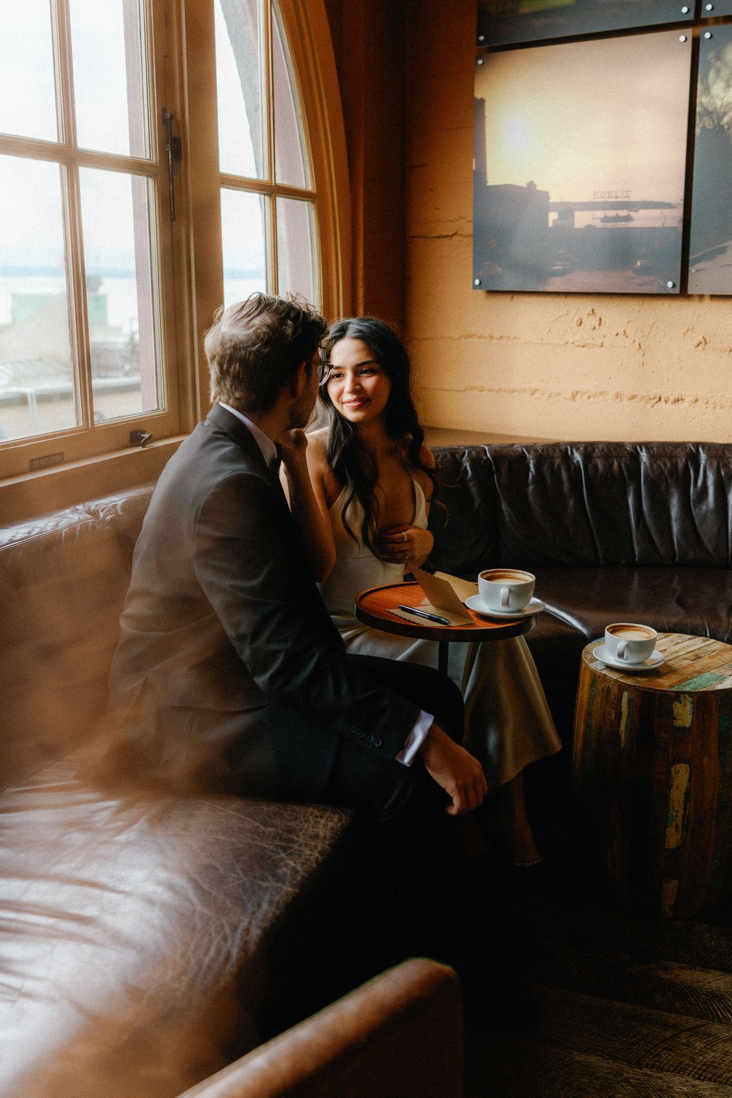 Cozy cafe interior with leather seating and warm lighting during a romantic moment.