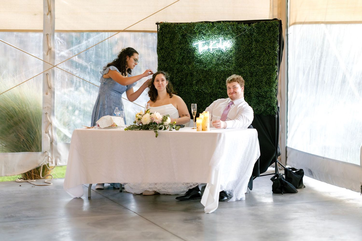 A couple in white wedding attire sits on a couch during a romantic photo session.