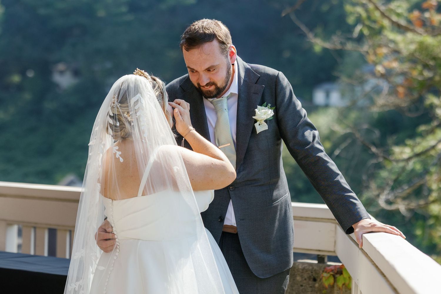 Couple sharing an intimate moment on an outdoor balcony during their wedding celebration.